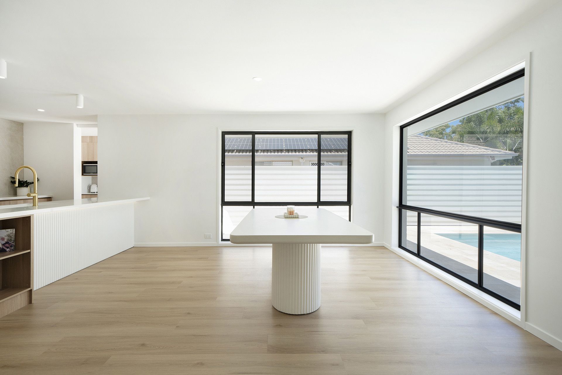 A Bright, Minimalist Dining Area Featuring a White Table — Reynolds Built In Little Mountain, QLD