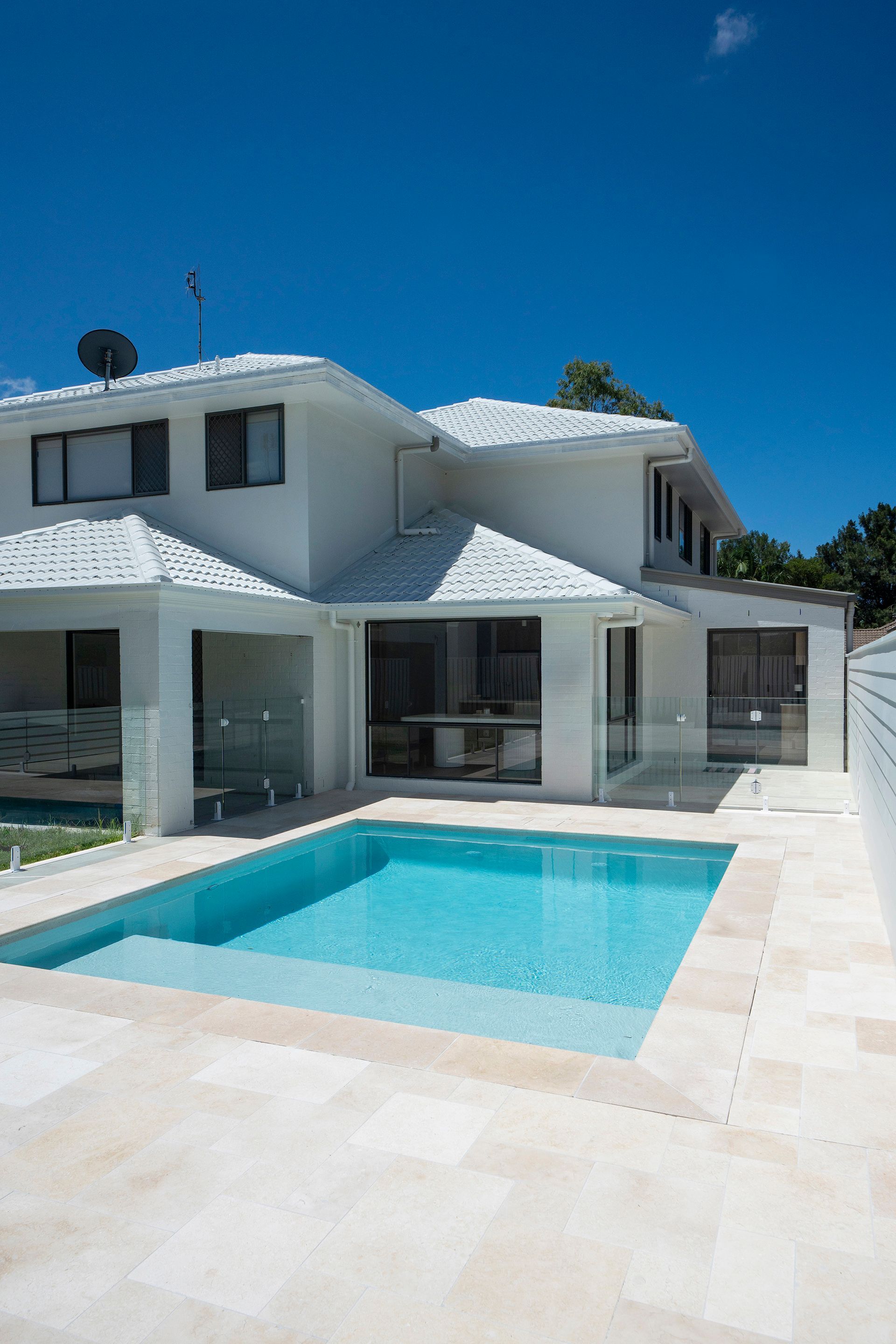 Modern White House With a Turquoise Pool Under a Bright Blue Sky — Reynolds Built In Moffat Beach, QLD