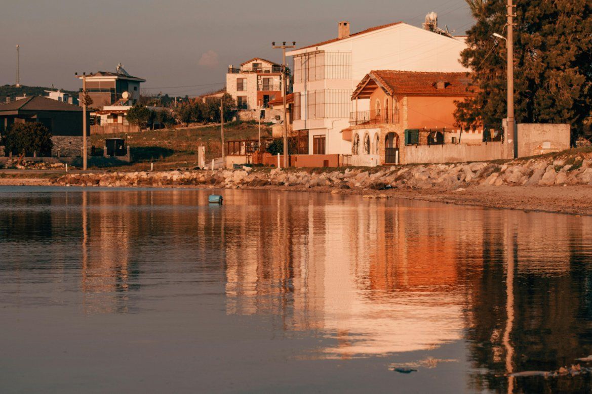 Sunlit Waterfront Houses Reflected in Calm Water at Sunset — Reynolds Built In Moffat Beach, QLD