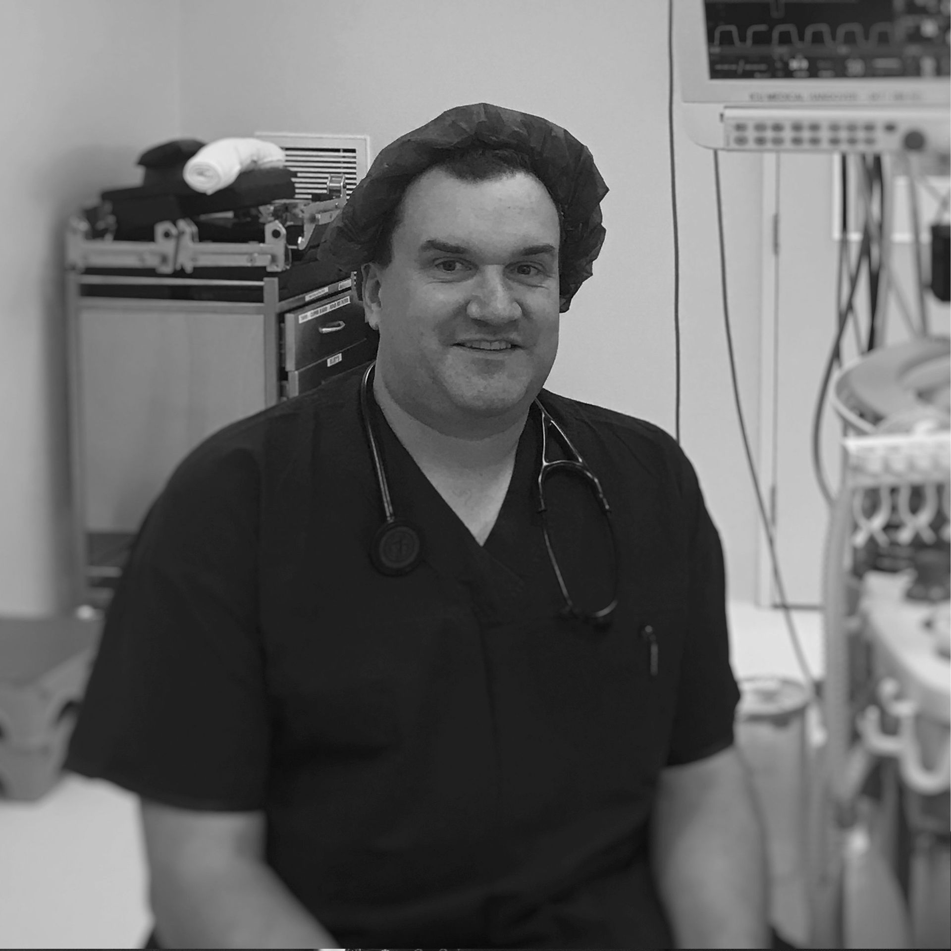 A black and white photo of a doctor with a stethoscope around his neck