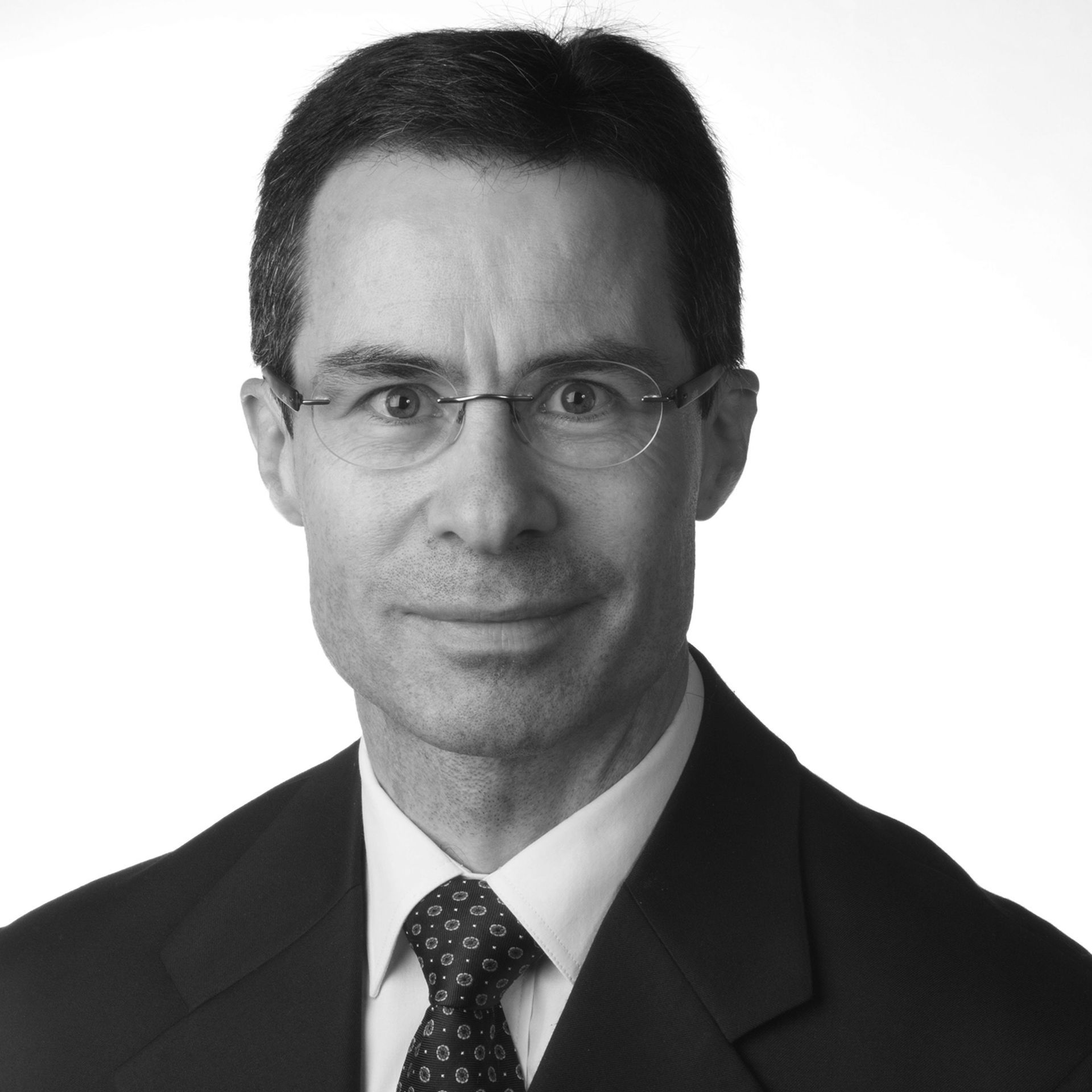 A man in a suit and tie is smiling for the camera