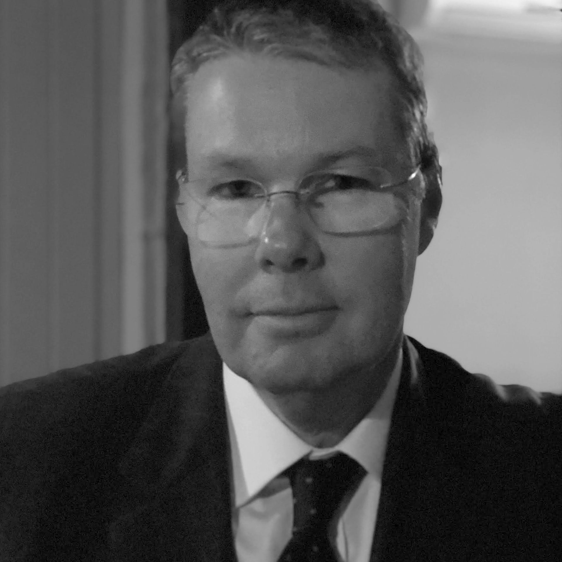 A man in a suit and tie is wearing glasses