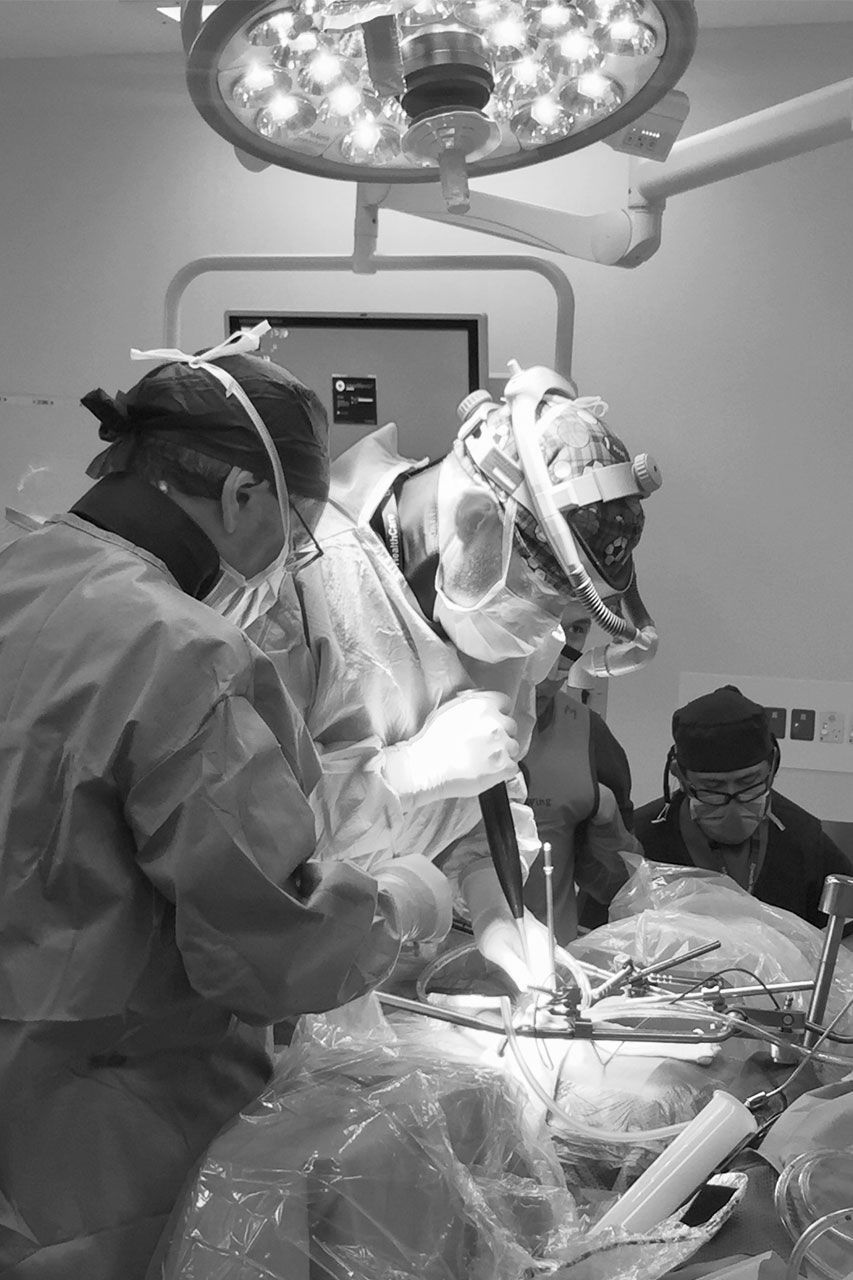 A group of surgeons are operating on a patient in an operating room.