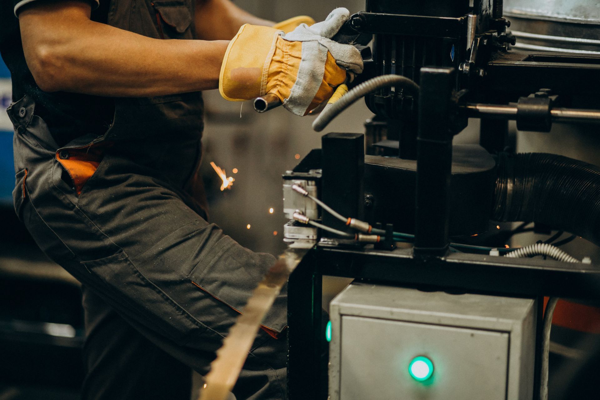 Operator using industrial saw; sparks from cutting.