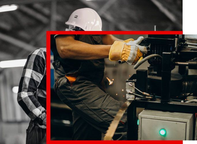 Man in work clothes and hard hat operating machinery.