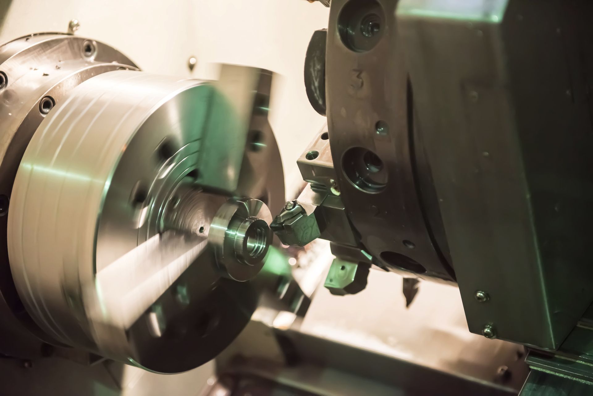 CNC lathe turning a spinning metal workpiece.