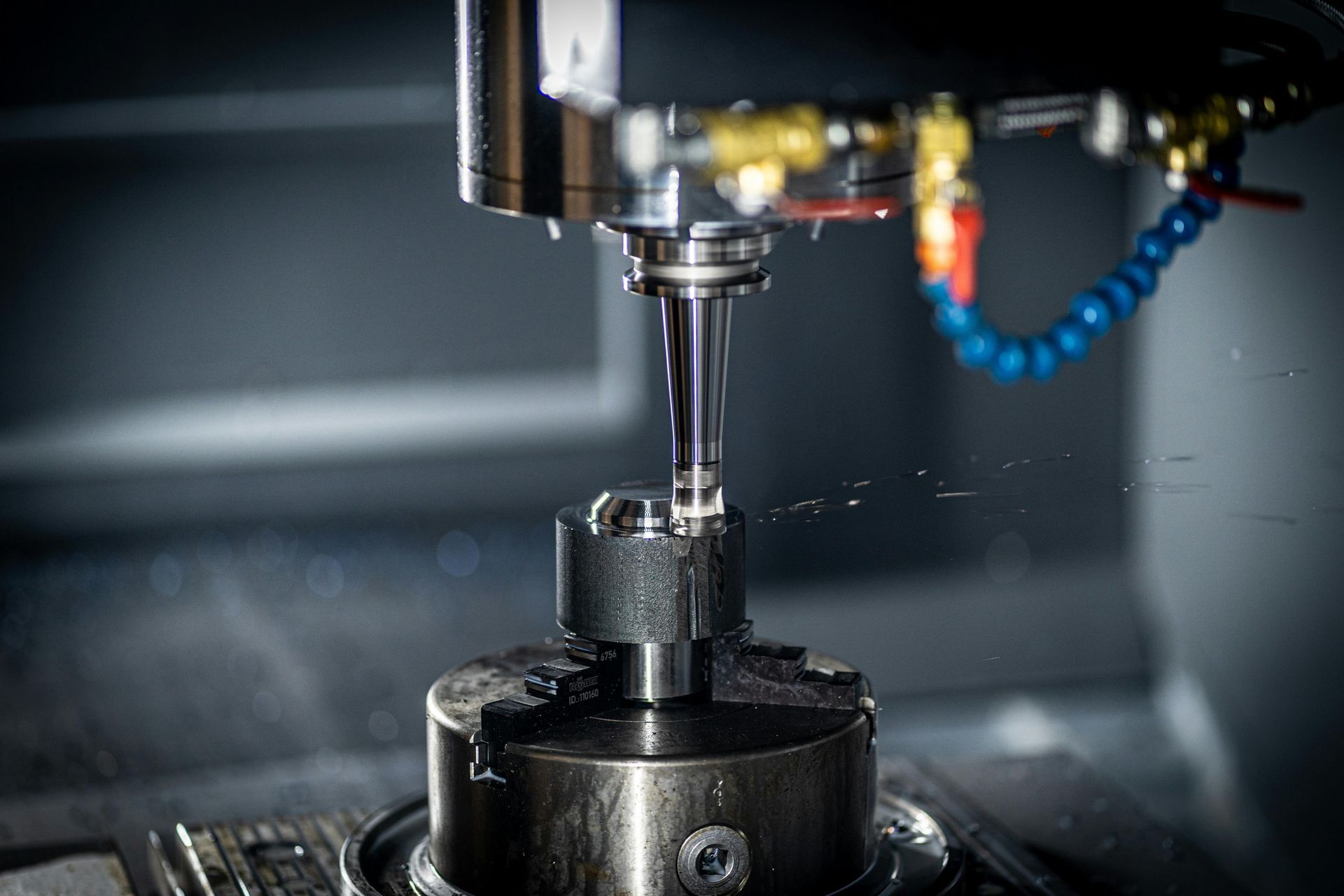 CNC spindle finishing a round metal component.
