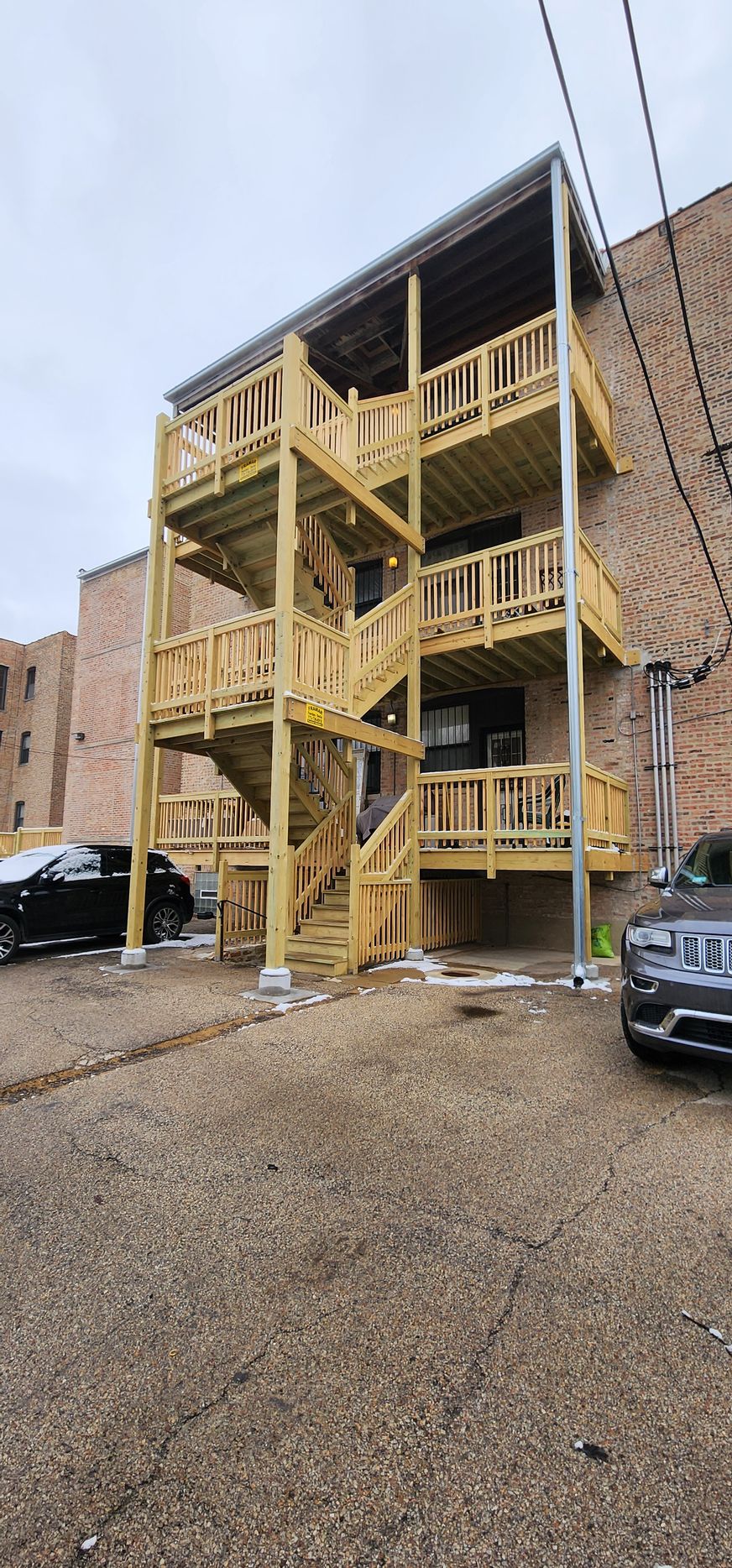 A building with stairs and a car parked in front of it.
