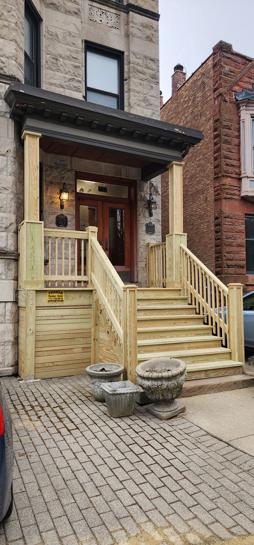 A wooden porch with stairs leading up to the front door of a building.