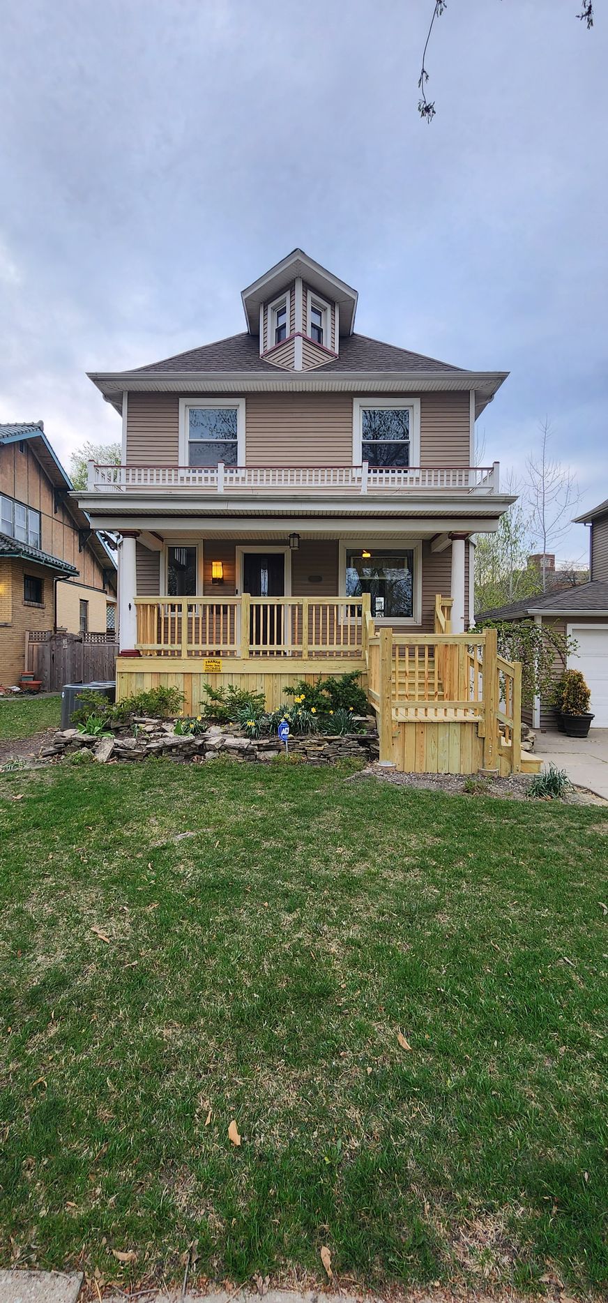 A large house with a large porch and a large lawn in front of it.