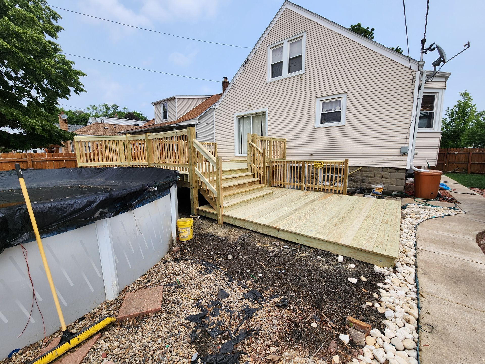 A house with a wooden deck next to a pool.