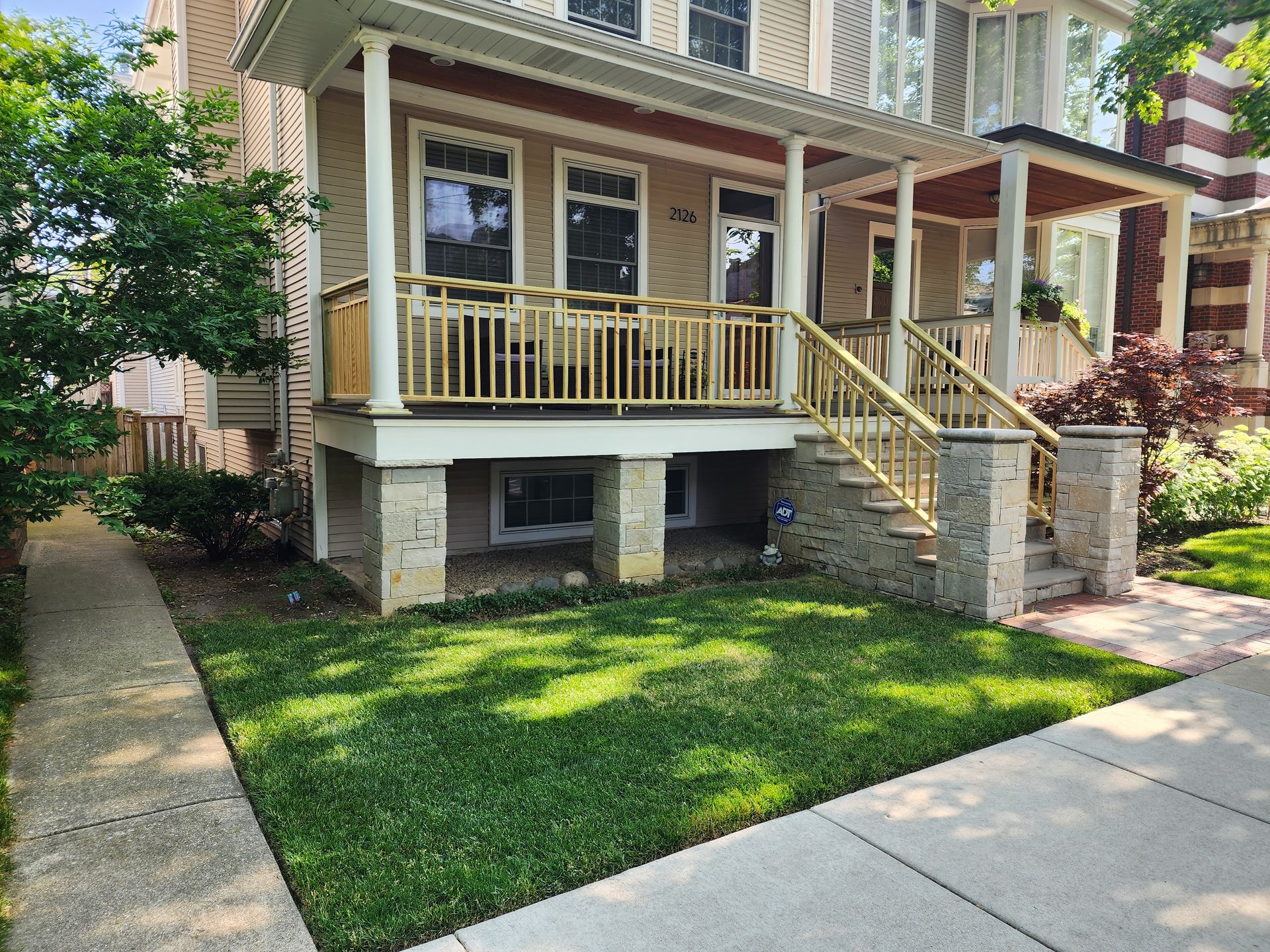 The front of a house with a large porch and stairs.