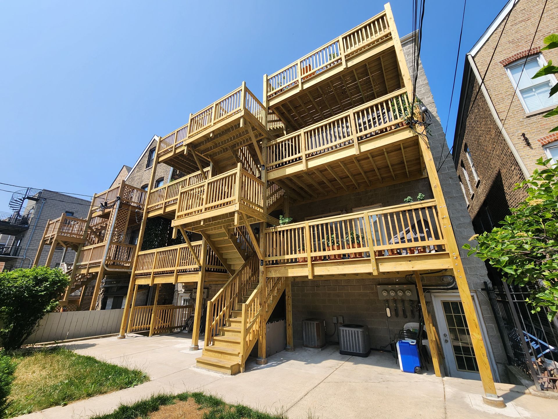 A building with a wooden deck and stairs on the side of it.