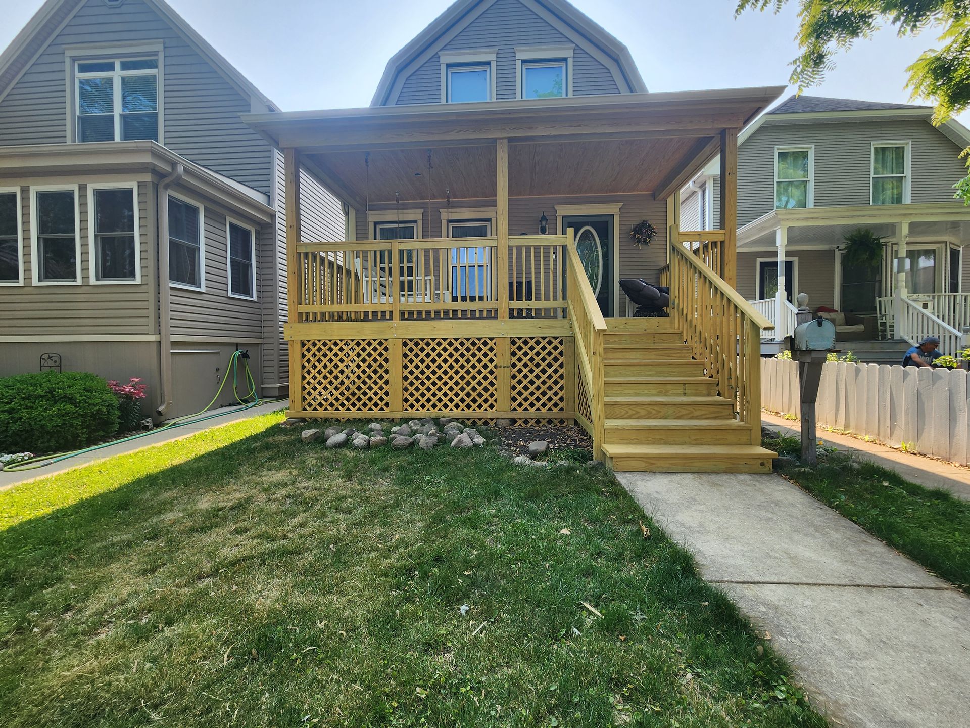 A house with a wooden deck and stairs in front of it.