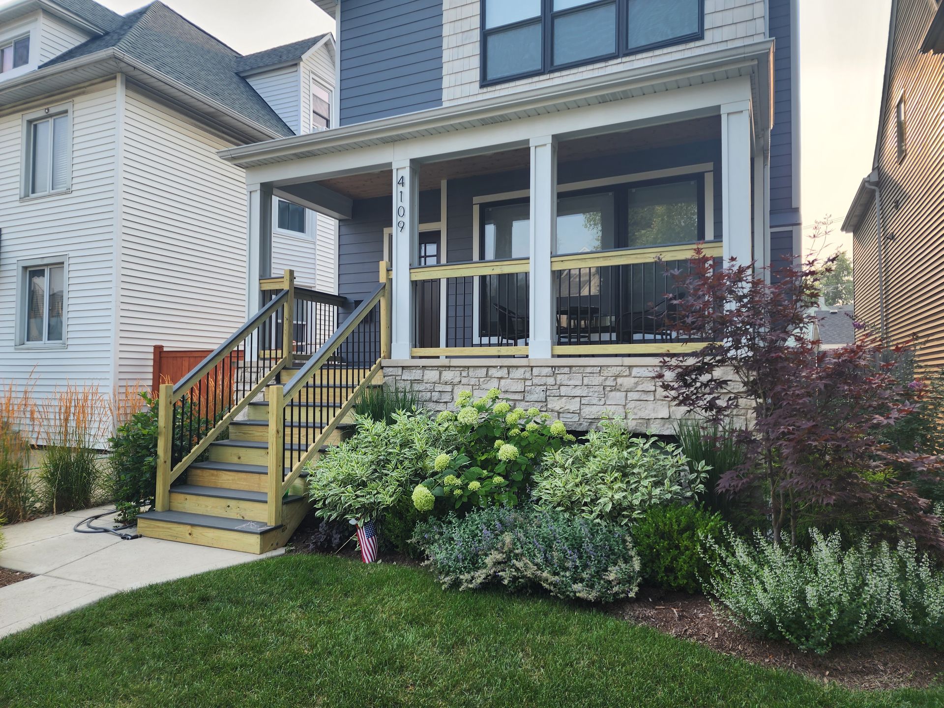 A stone house with wooden stairs leading up to the front door.