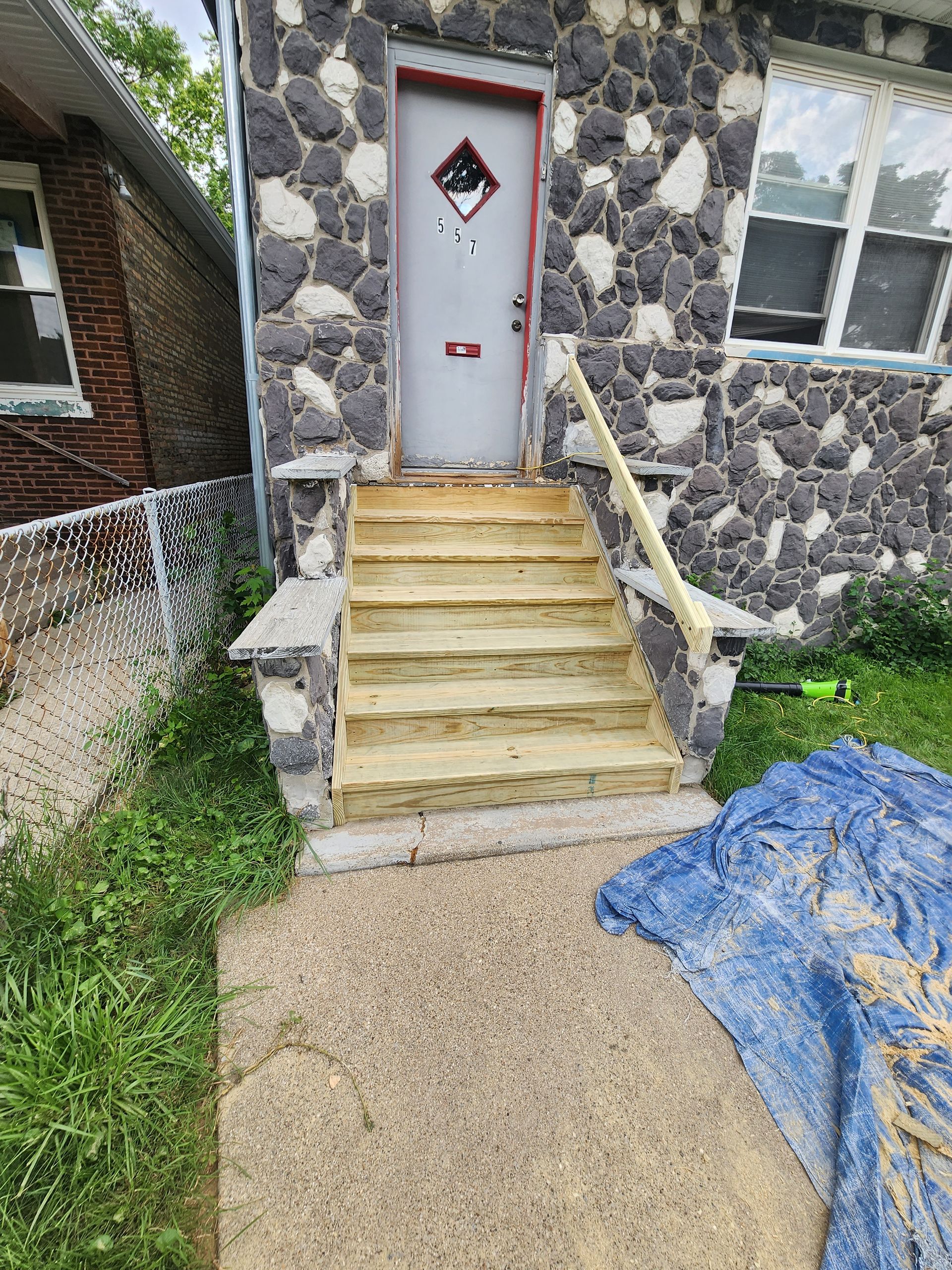 A stone house with wooden stairs leading up to the front door.
