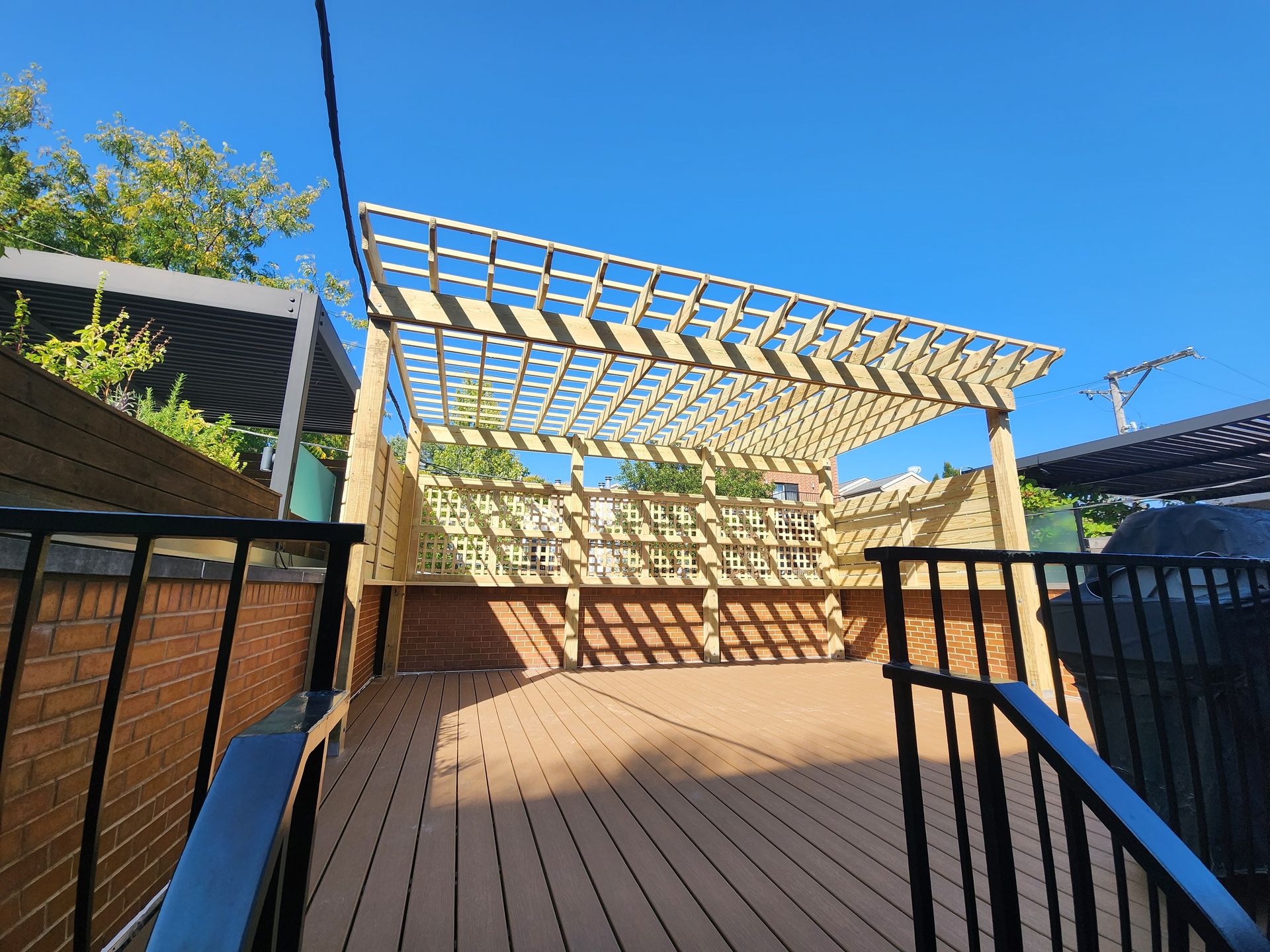 A wooden deck with a pergola on top of it.