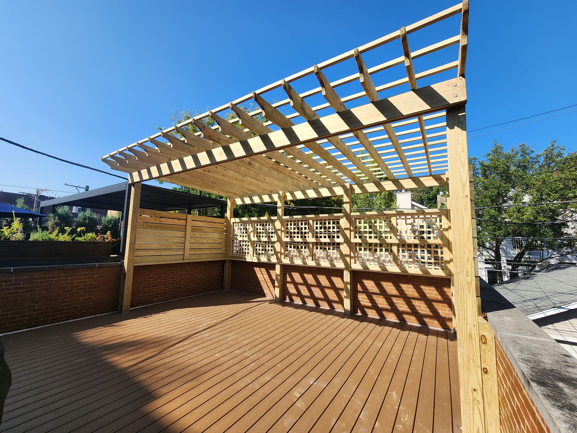 A wooden deck with a pergola on top of it.