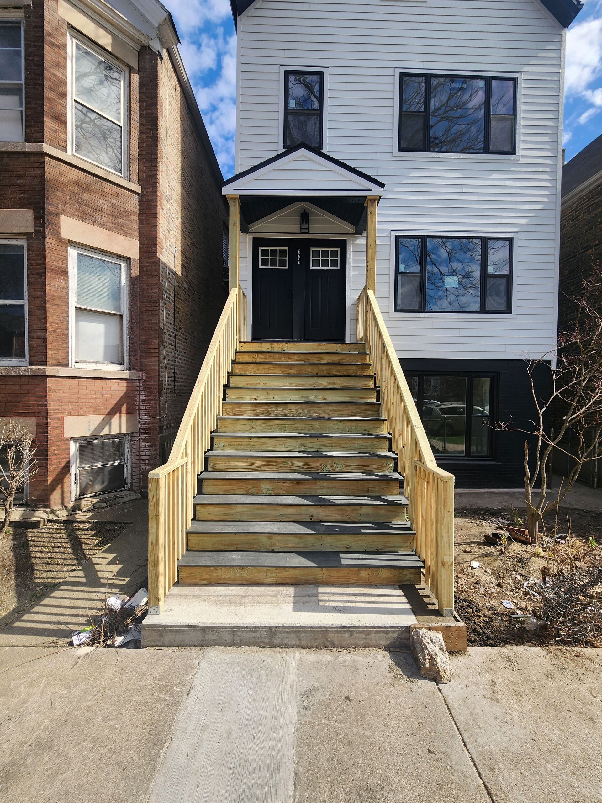 A house with wooden stairs leading up to the front door.