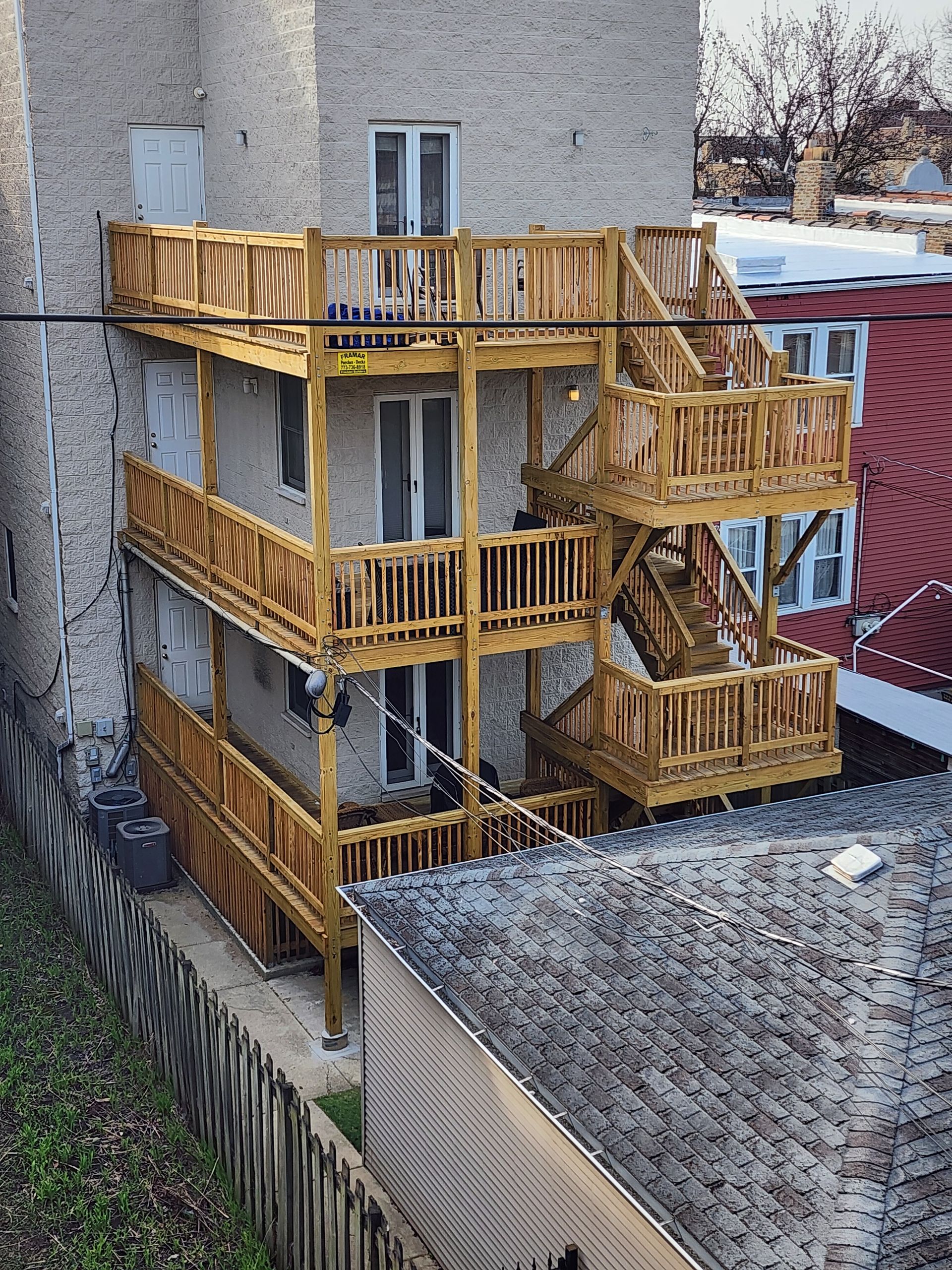 A brick building with a wooden deck and stairs.