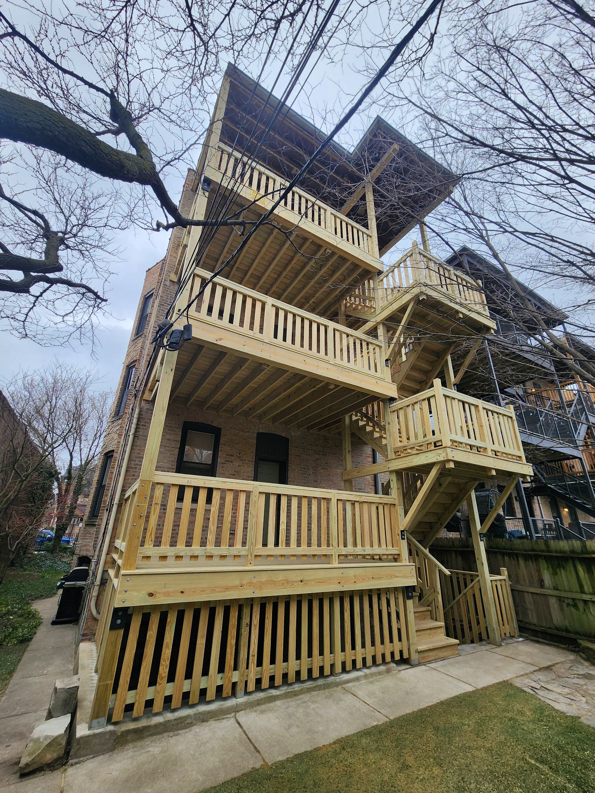 A large building with a wooden deck and stairs.