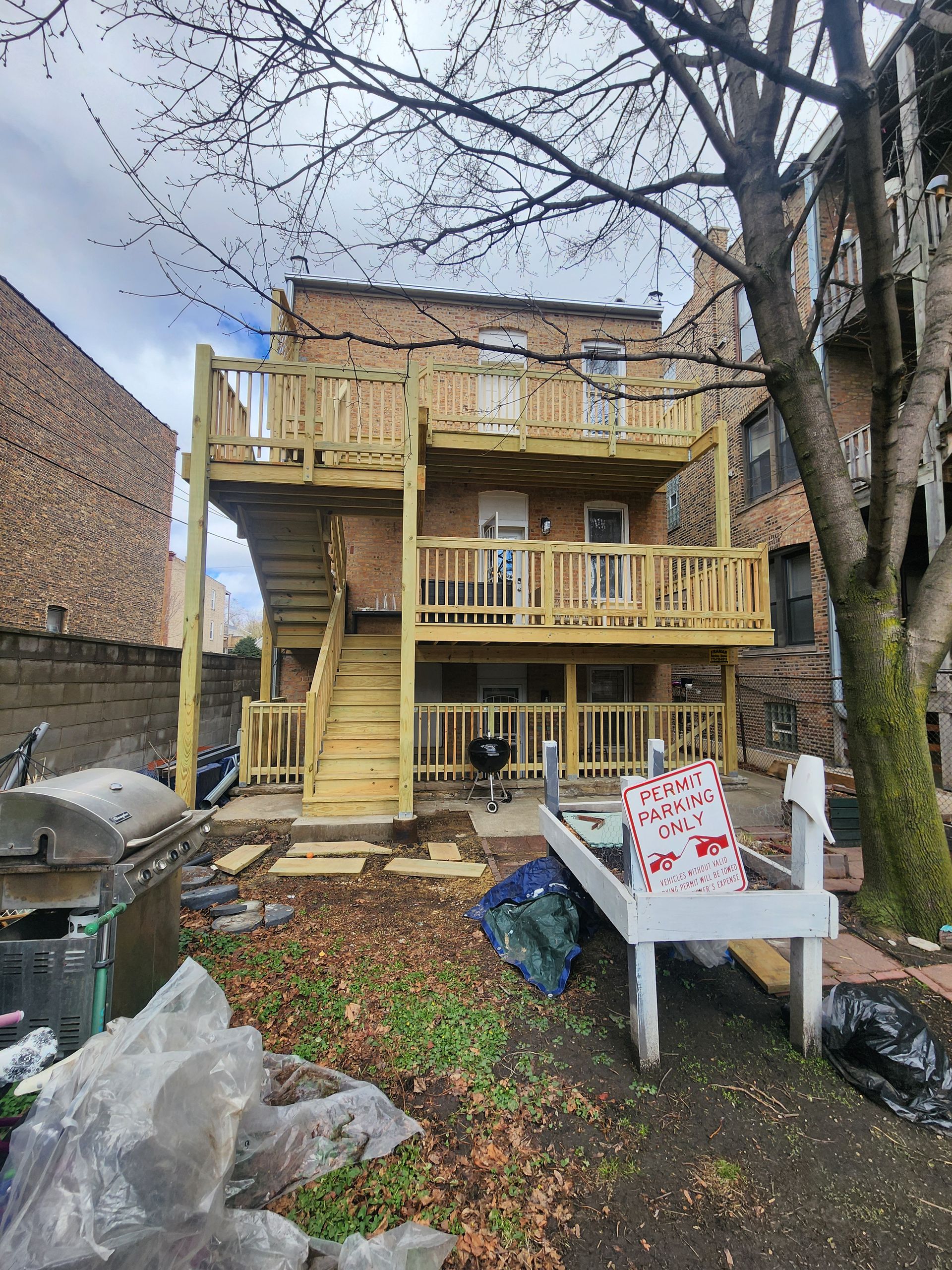 A wooden deck is being built in the backyard of a house.