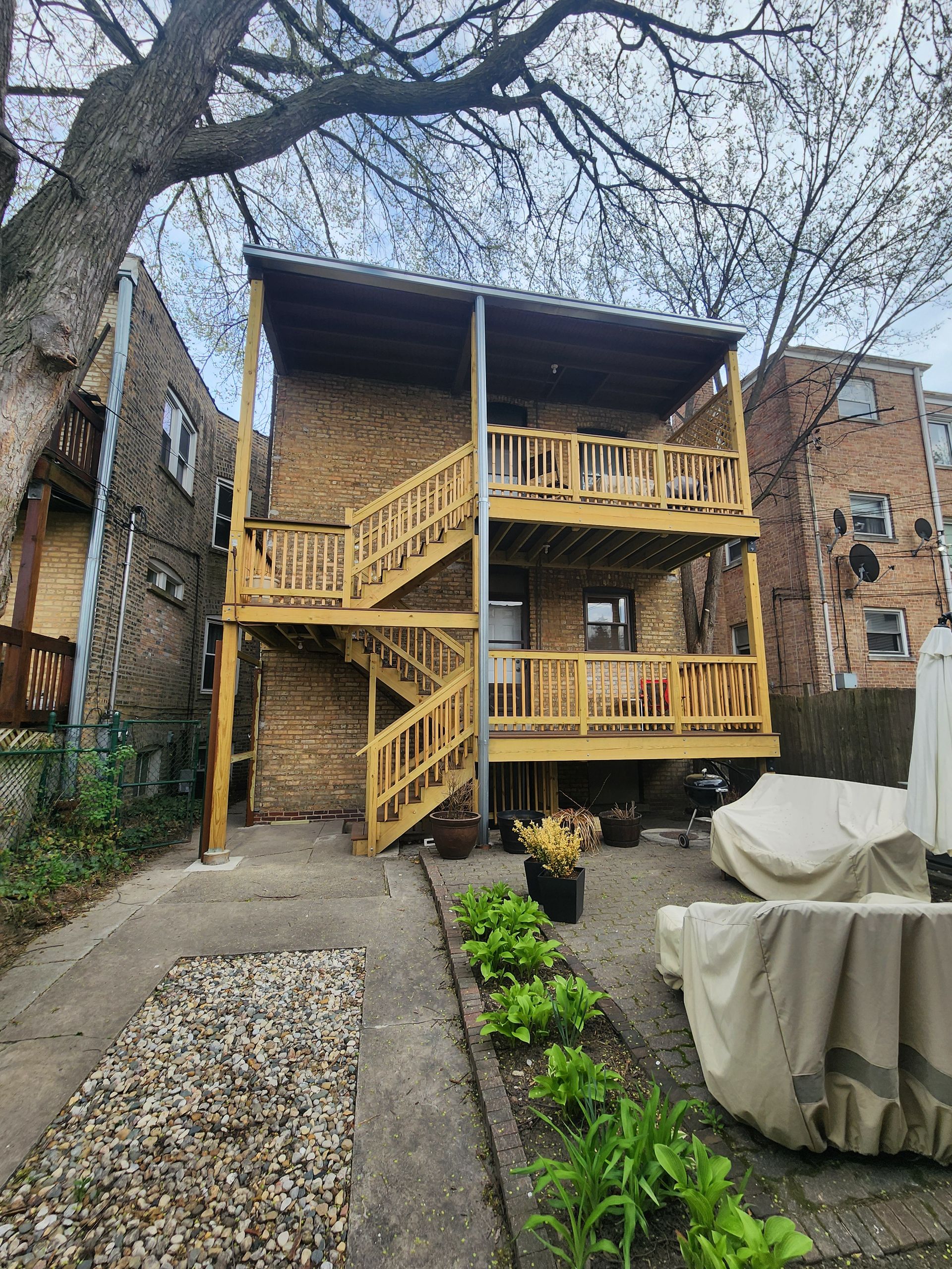 The back of a house with a wooden deck and stairs.