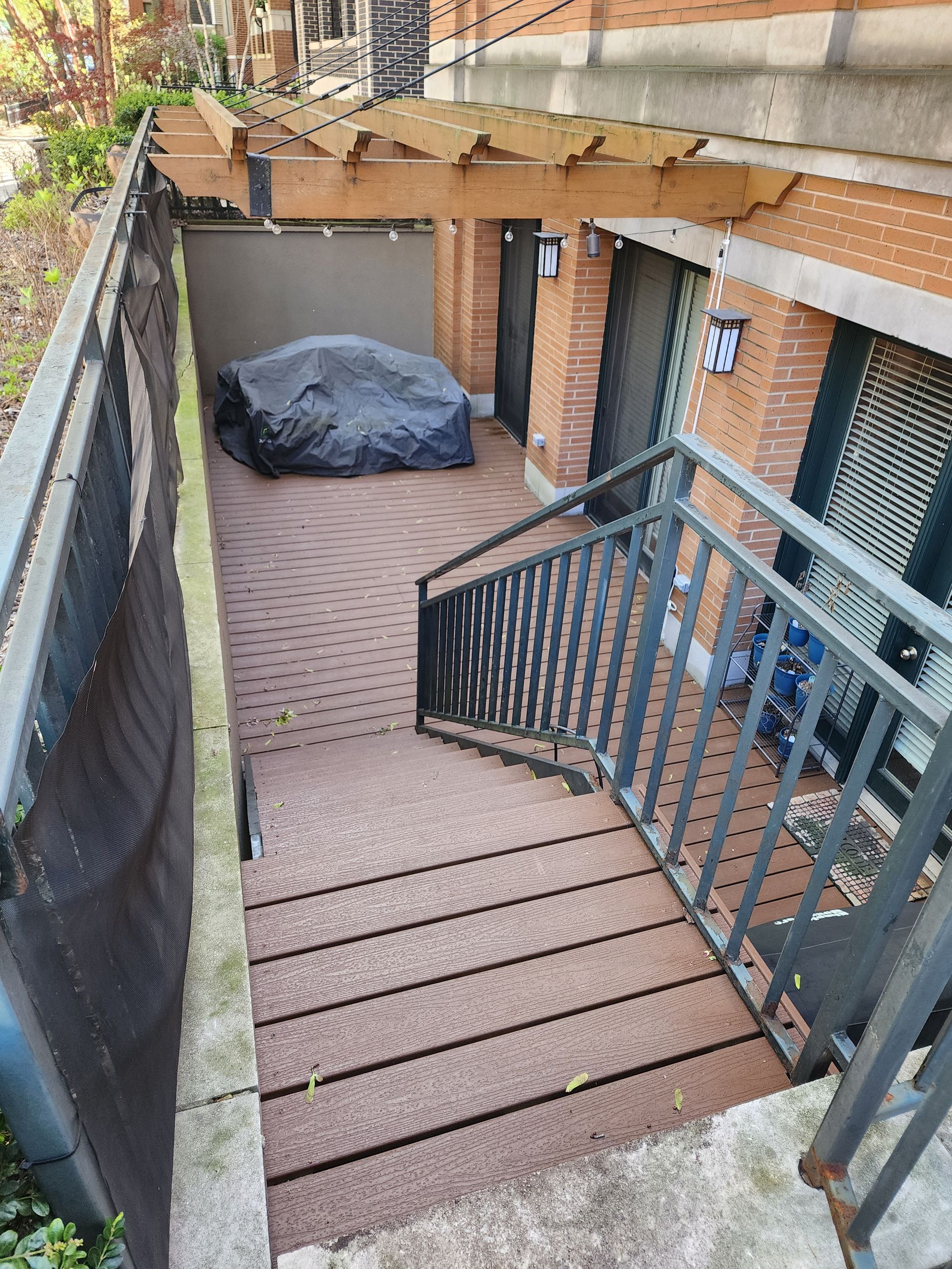 A set of stairs leading up to a brick building with a pergola.