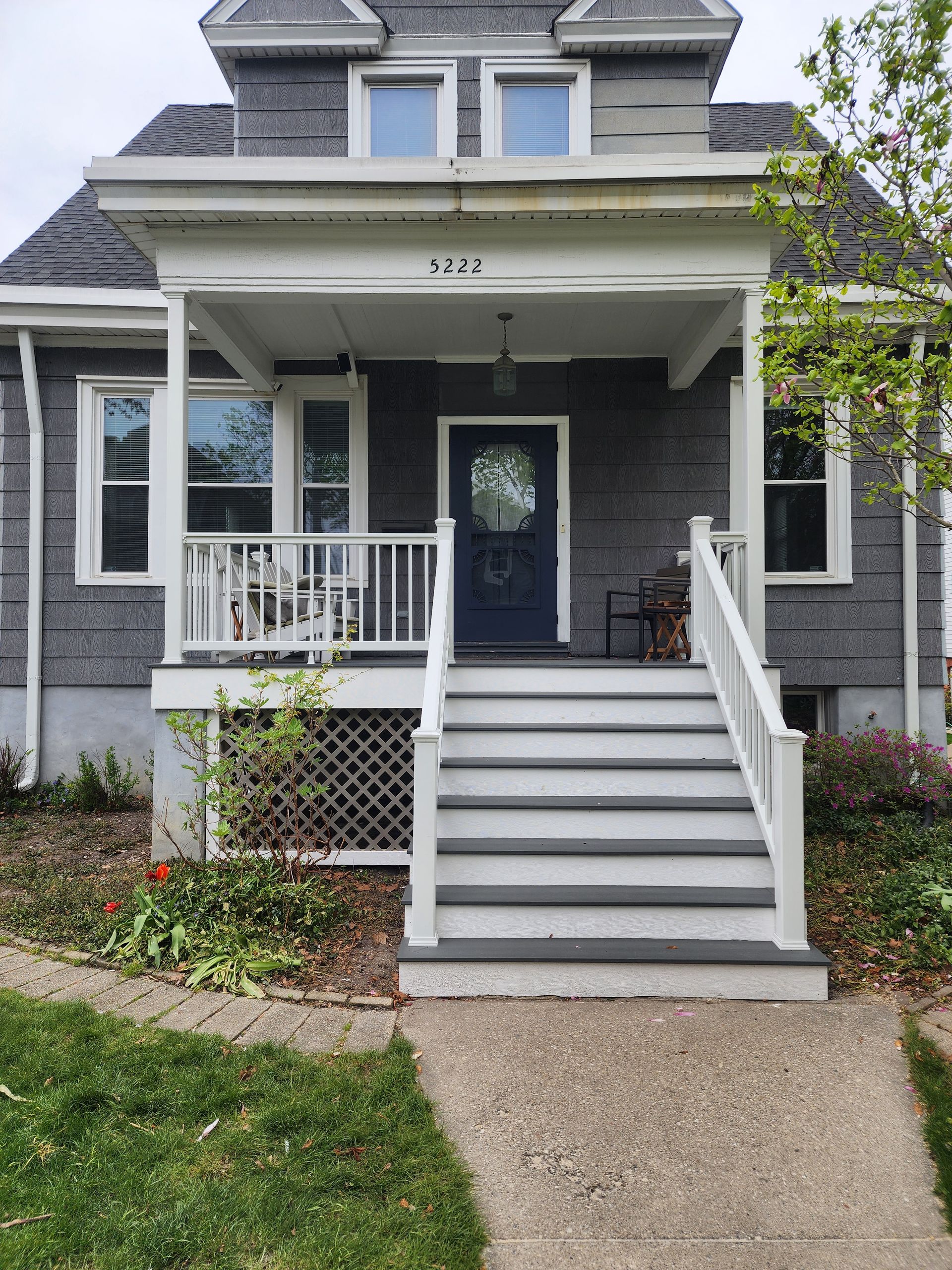 A house with a porch and stairs leading up to it.