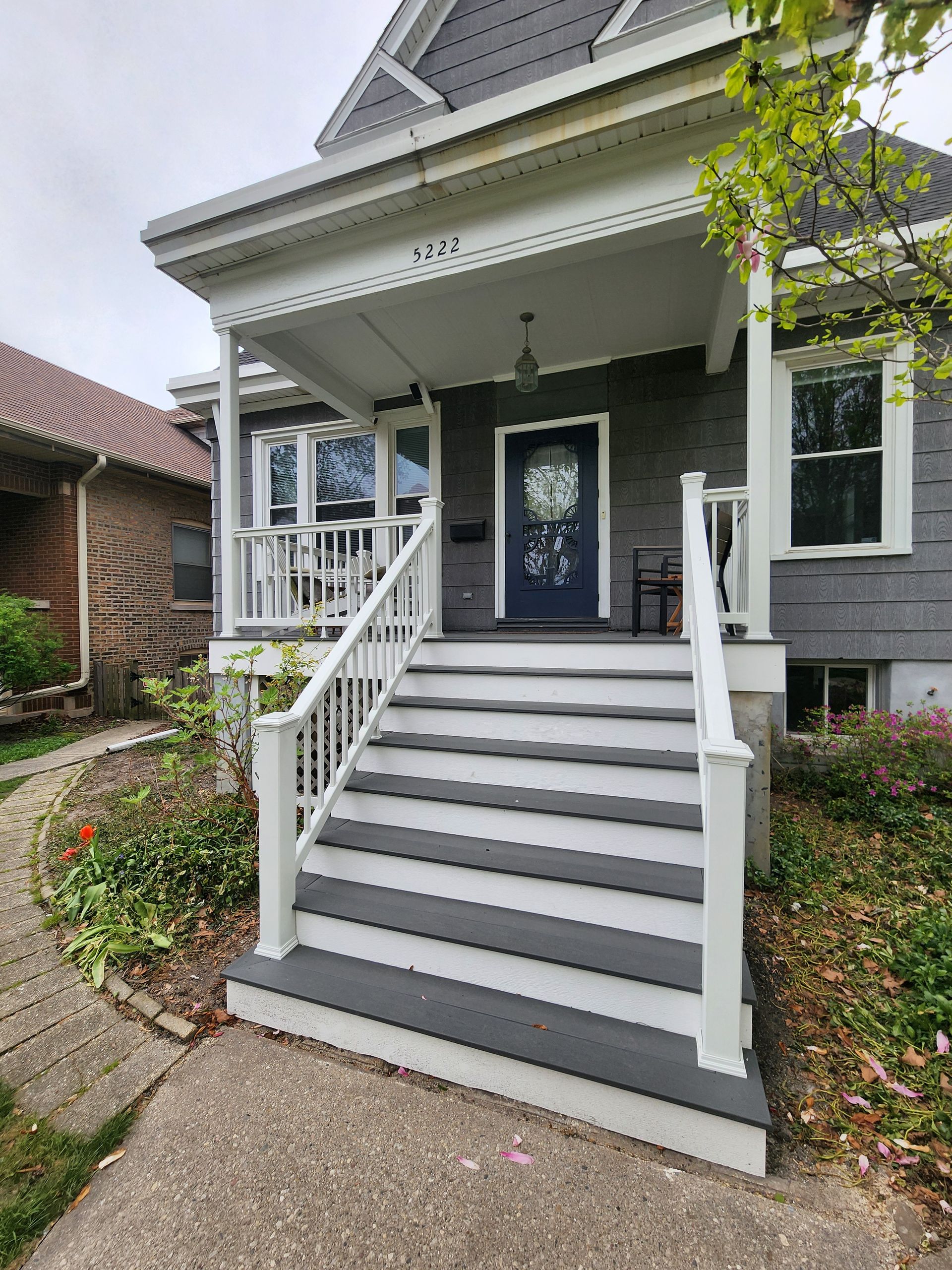 A house with a porch and stairs leading up to it.