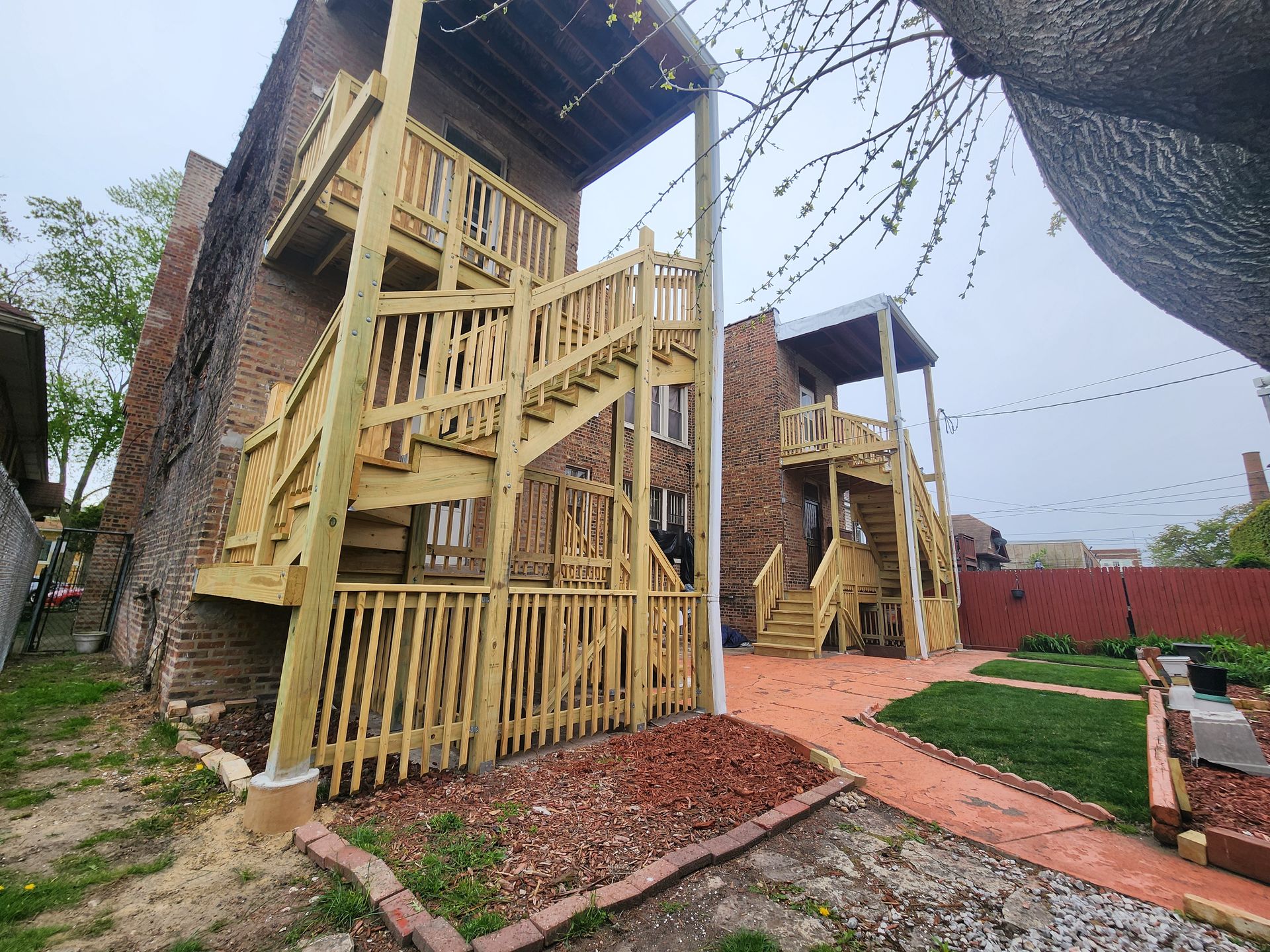 A house with a wooden deck and stairs on the side of it.