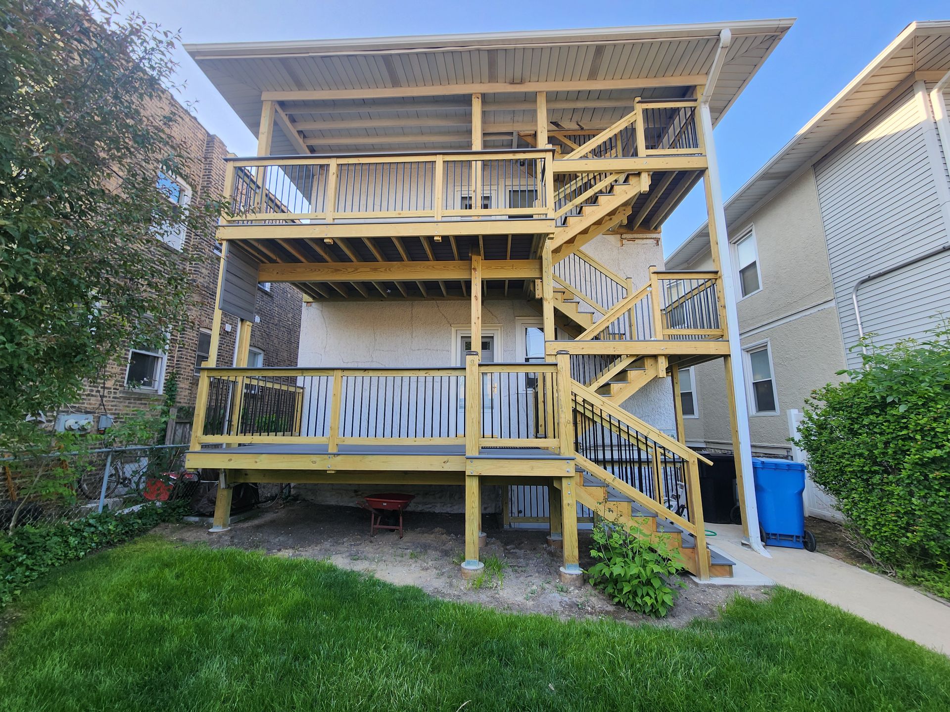 A house with a wooden deck and stairs in the backyard.