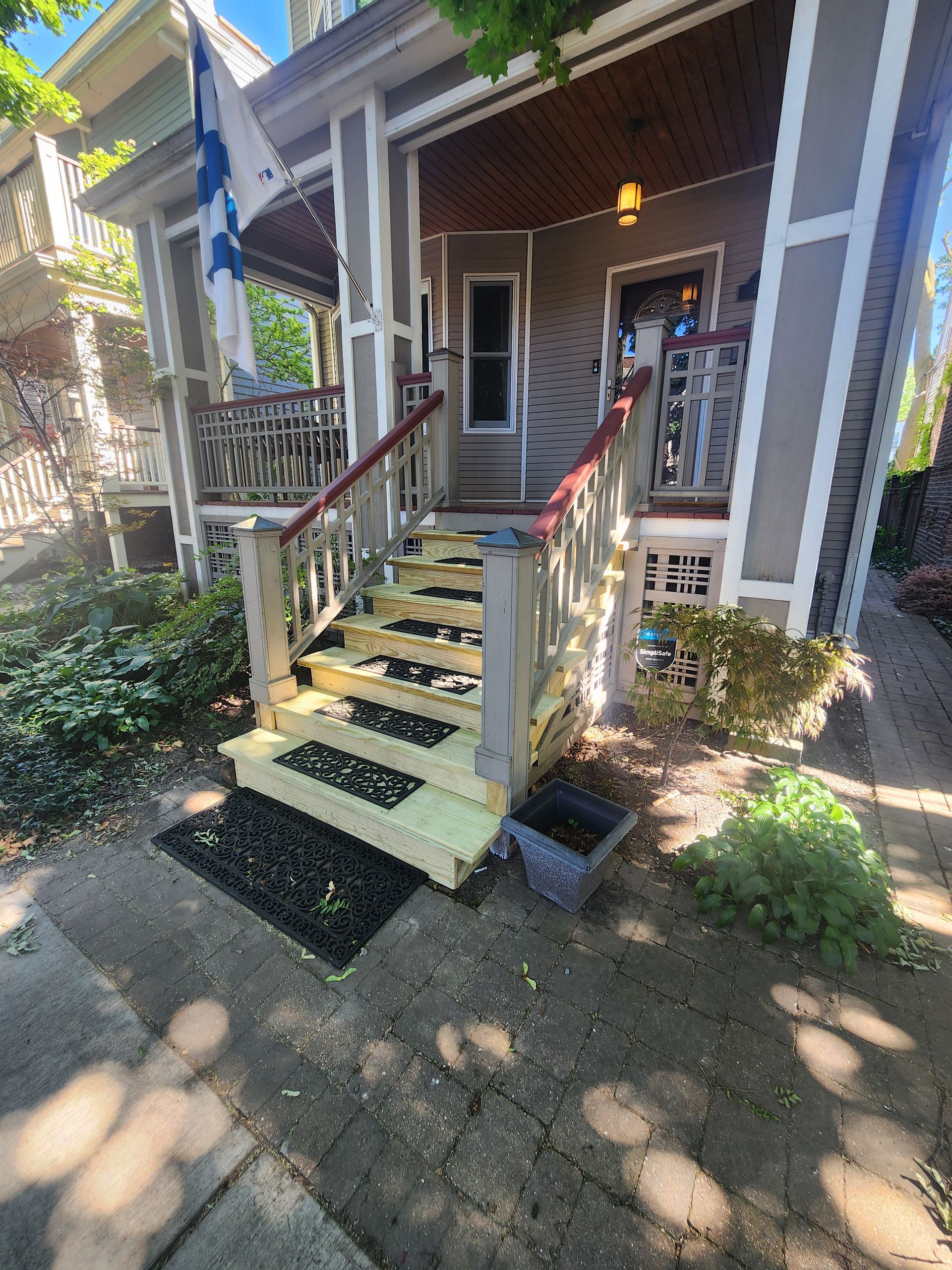 The front of a house with a wooden porch and stairs.