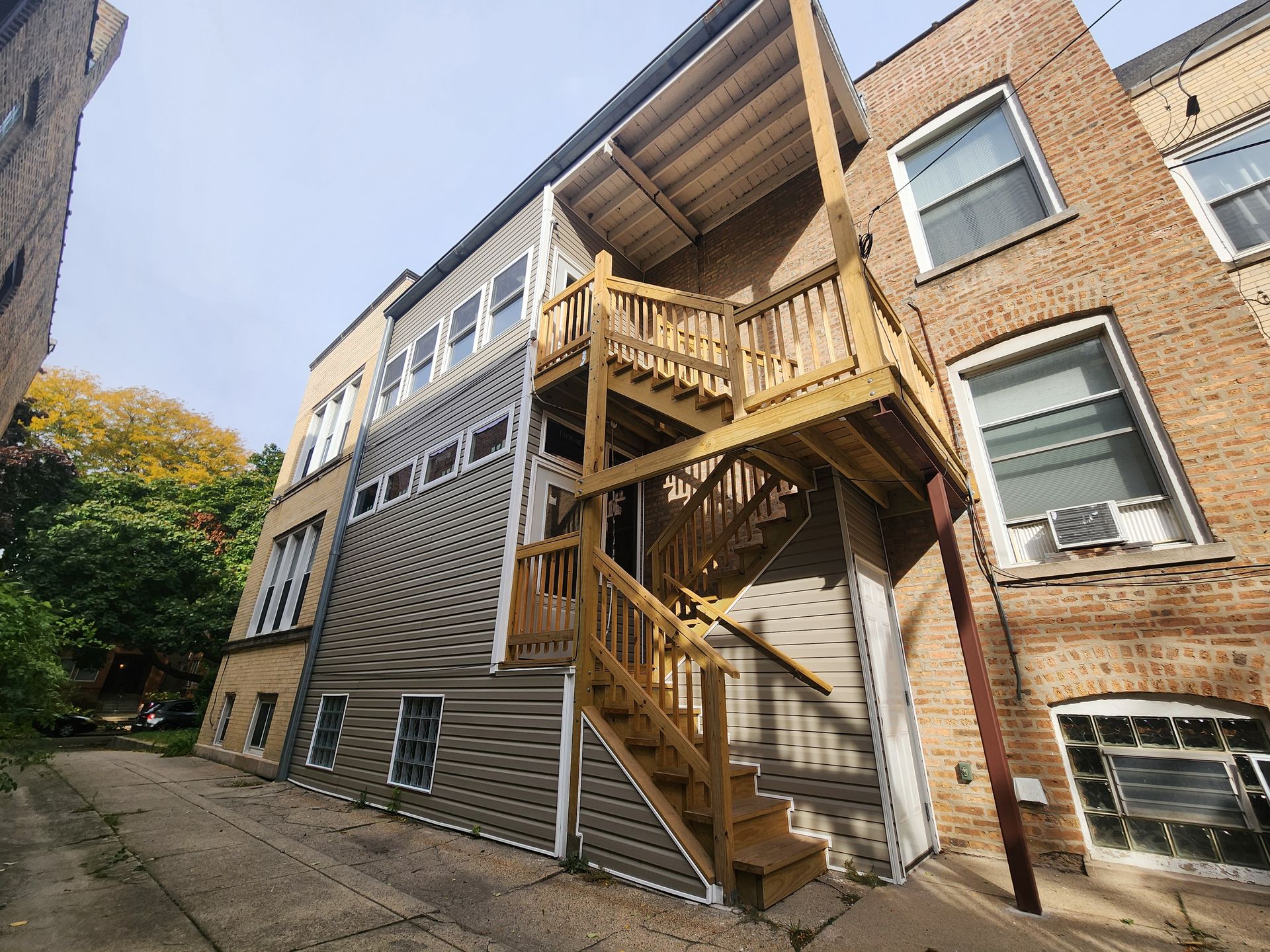 A brick building with a wooden deck and stairs.