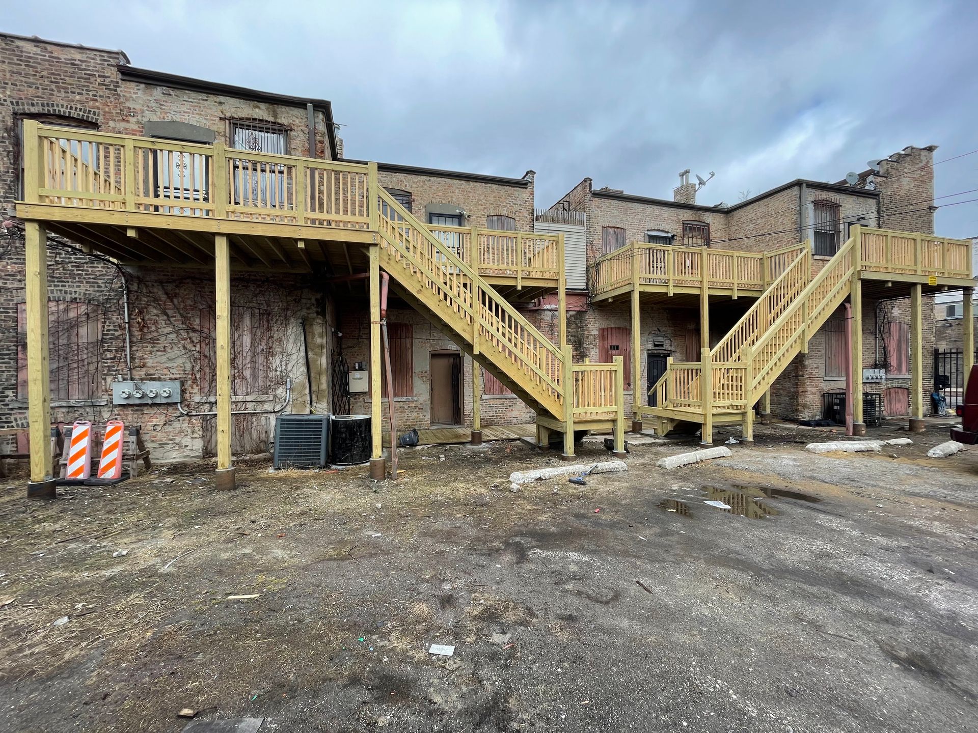 A building with a wooden deck and stairs on the side of it.