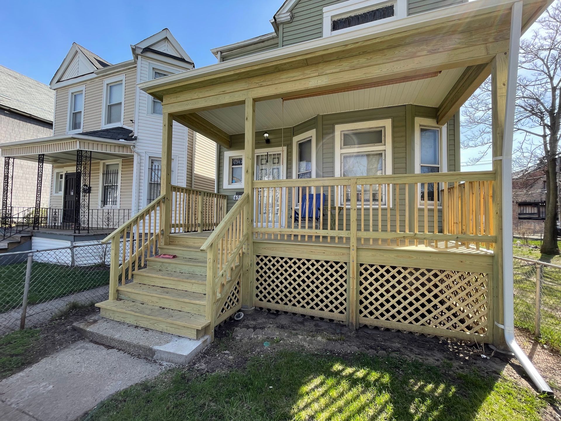 A house with a wooden porch and stairs in front of it.