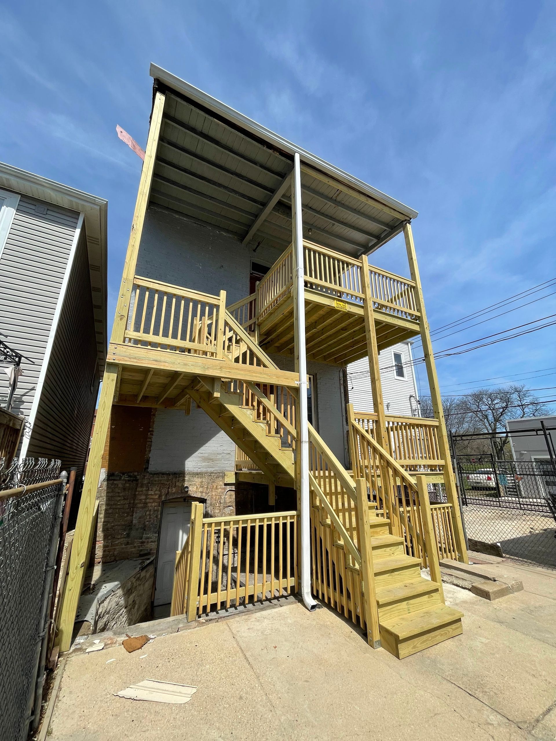 A house with a wooden deck and stairs on the side of it.