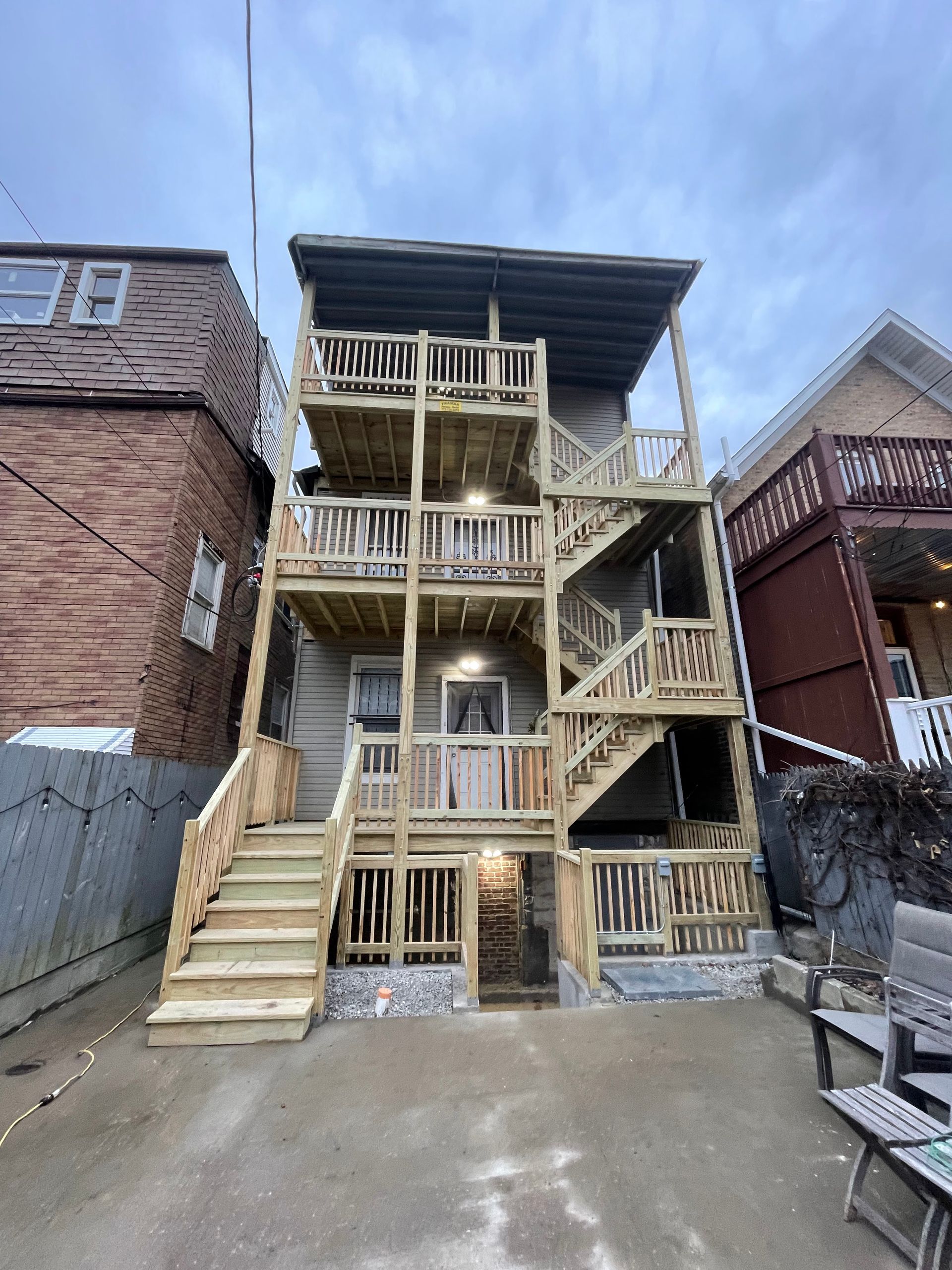 A large wooden house with stairs leading up to the second floor.