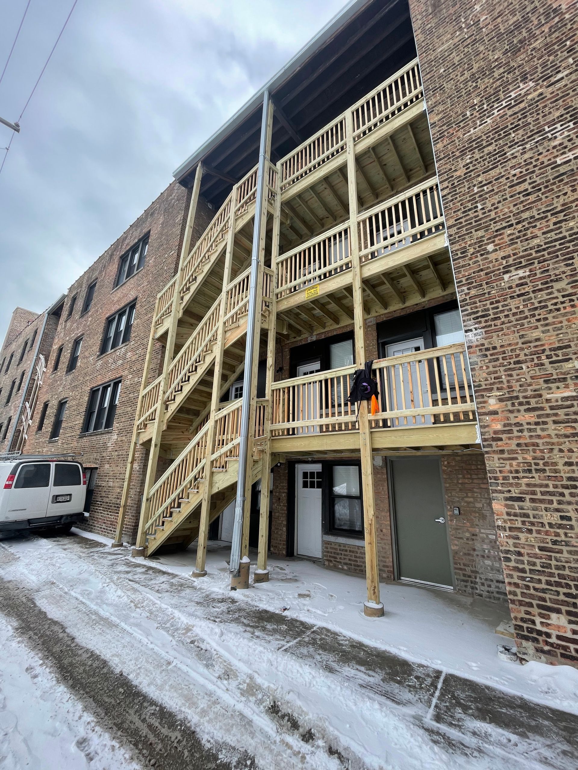 A large brick building with a wooden deck and stairs.