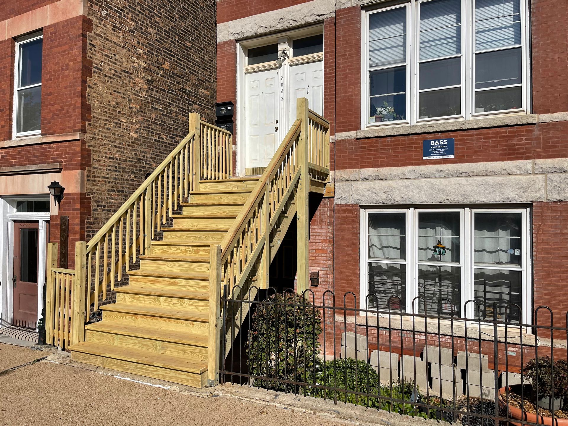 A brick building with wooden stairs leading up to the front door.
