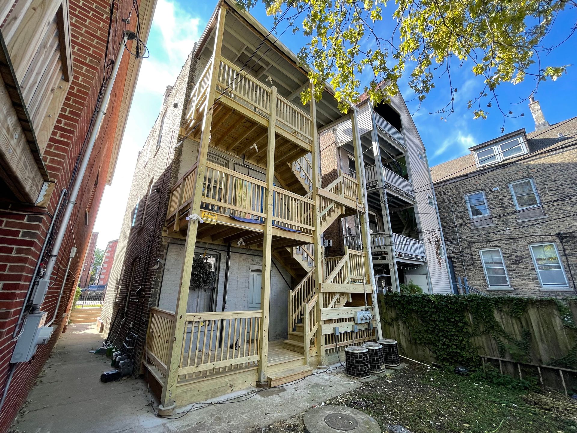 A building with a wooden deck and stairs on the side of it.