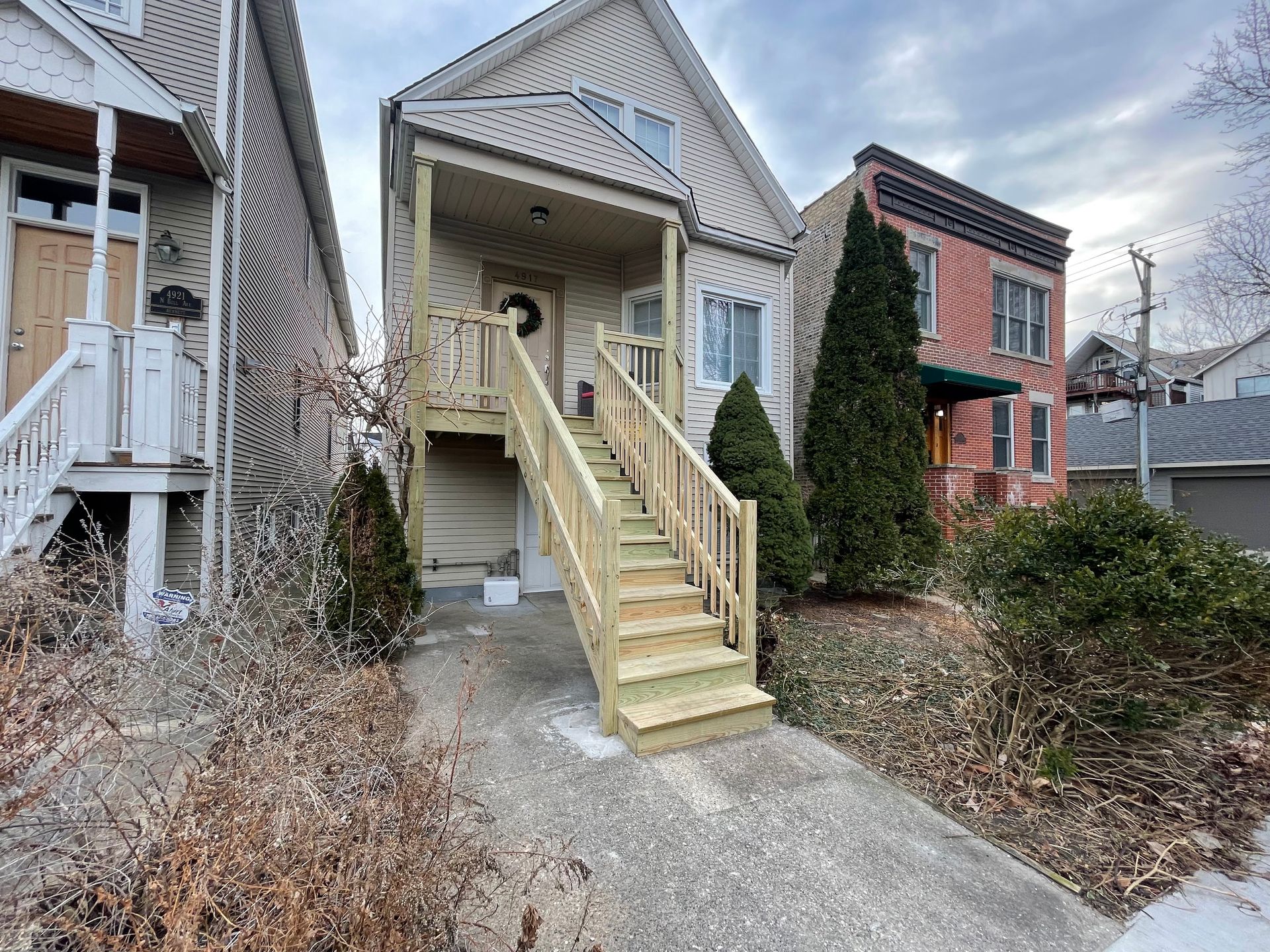 A house with wooden stairs leading up to the front door.