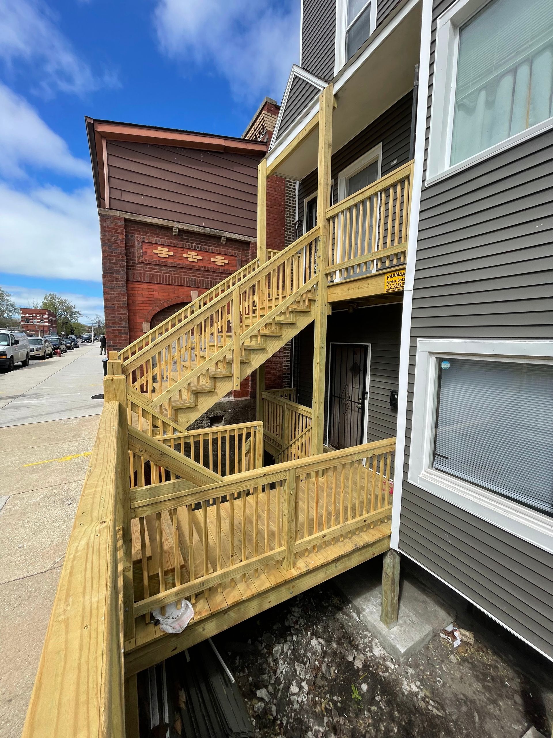A wooden deck with stairs leading up to a building.