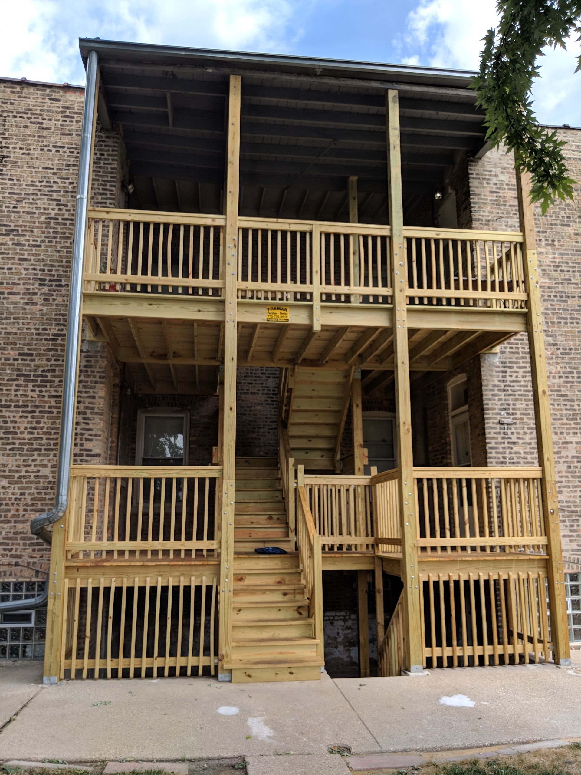 A brick building with a wooden deck and stairs.