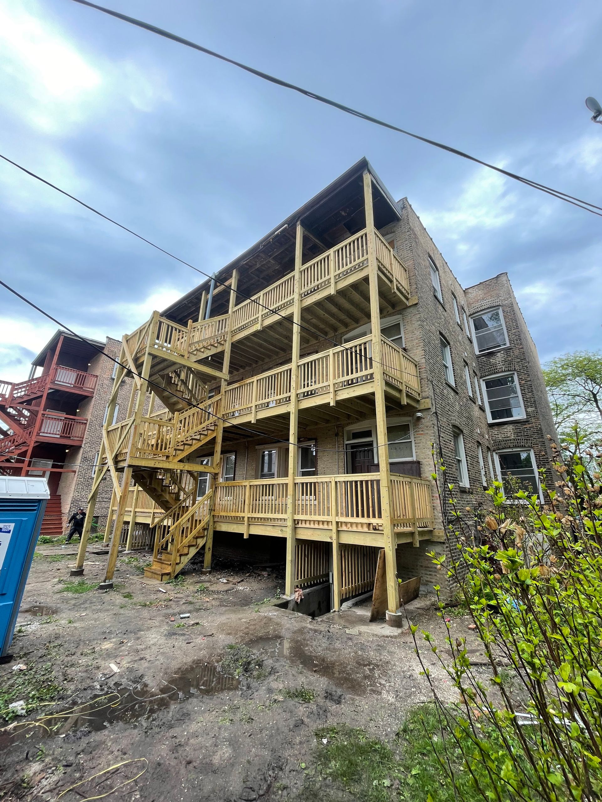 A large apartment building with a wooden deck and stairs.