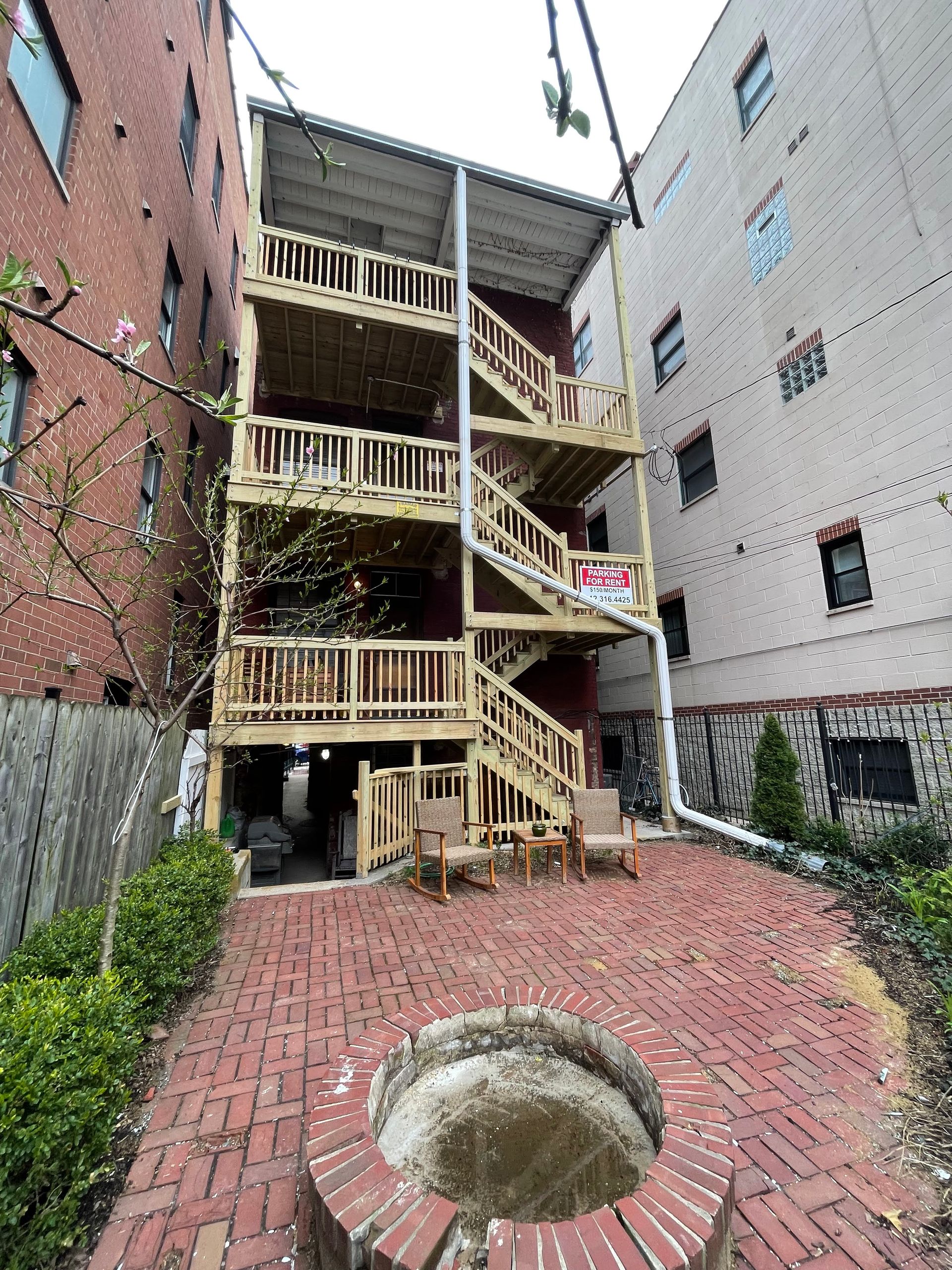 A building with stairs and a brick walkway in front of it.