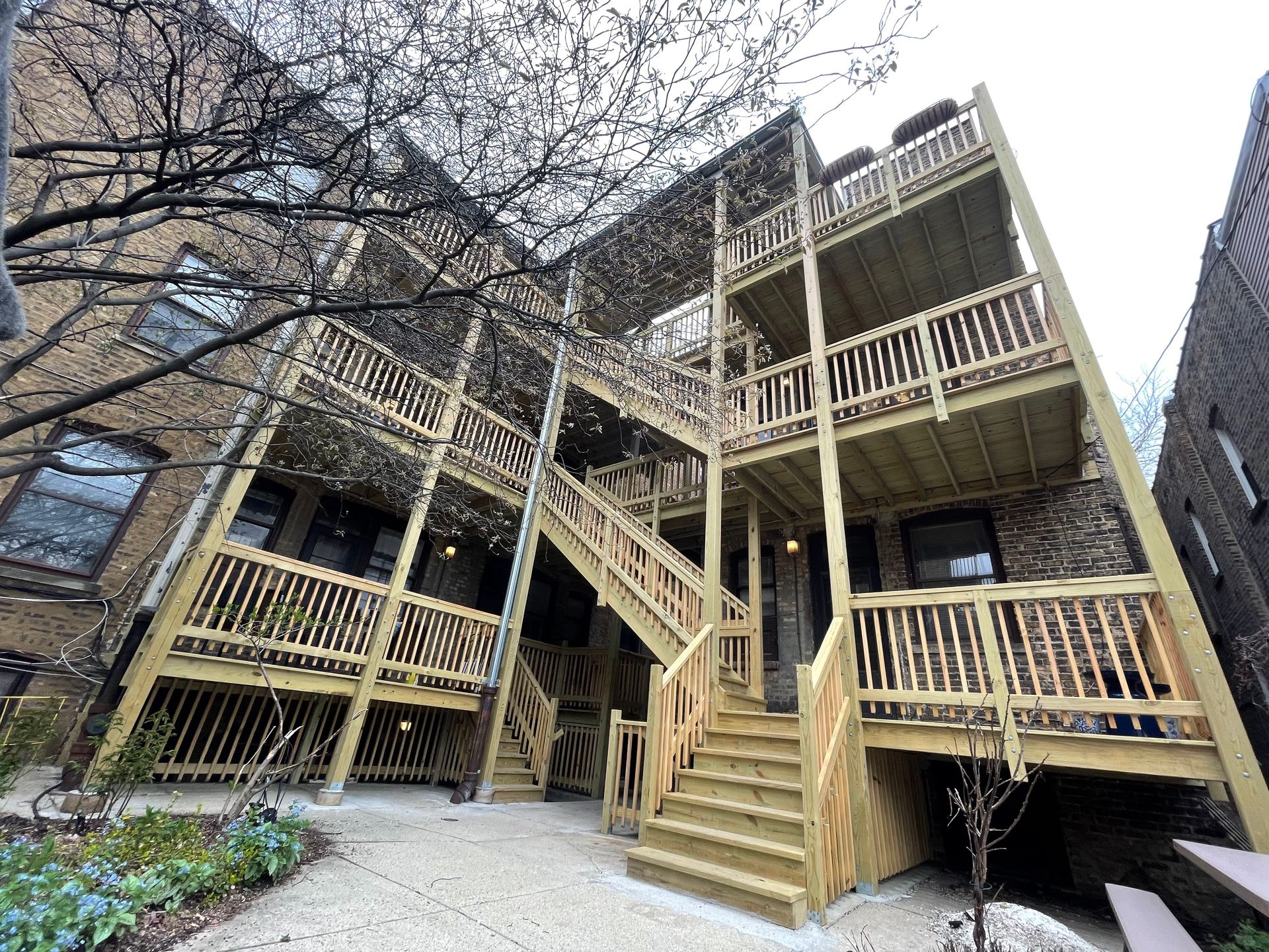 A building with a wooden deck and stairs in front of it.