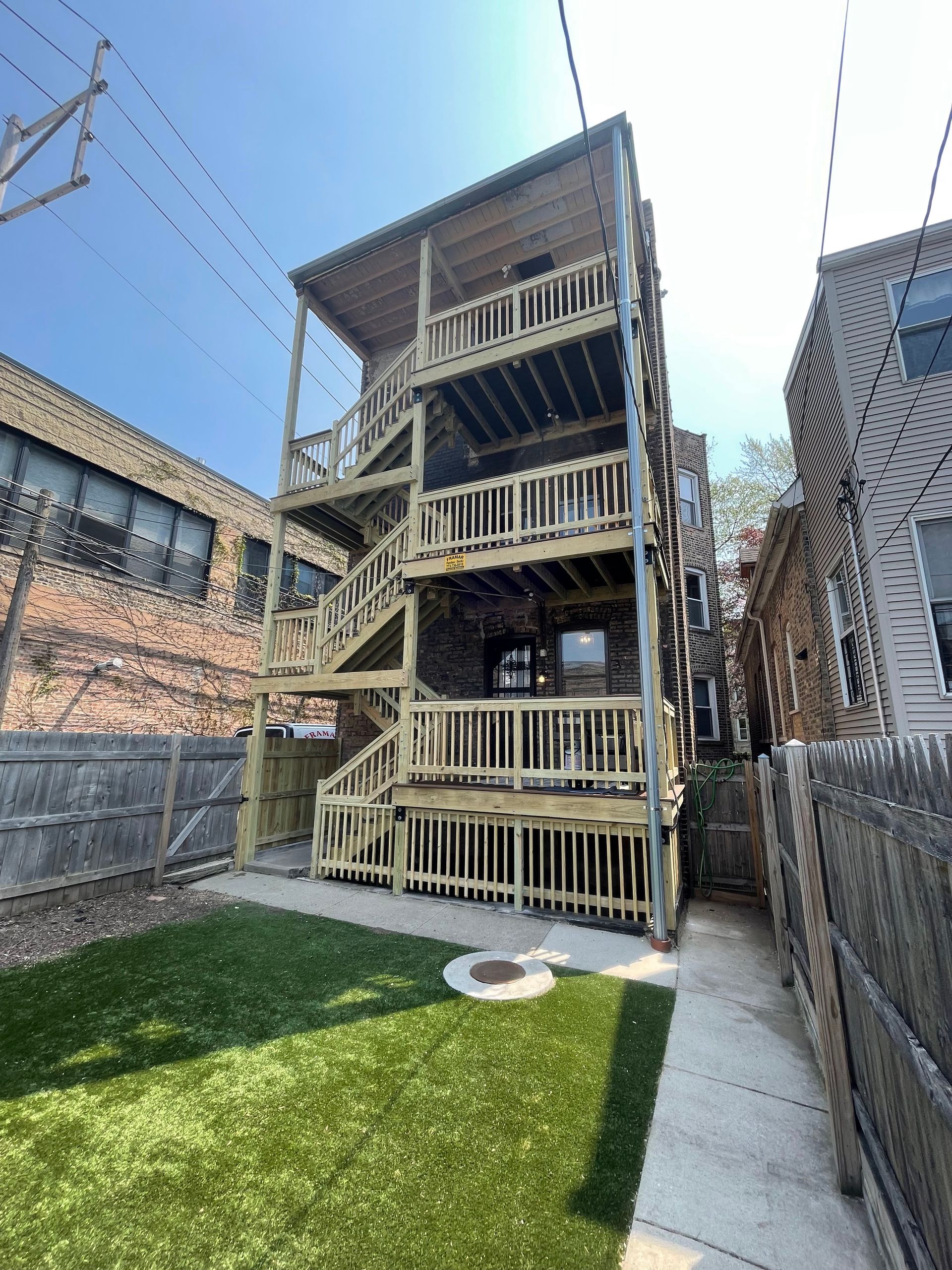 A house with a wooden deck and stairs in the backyard.