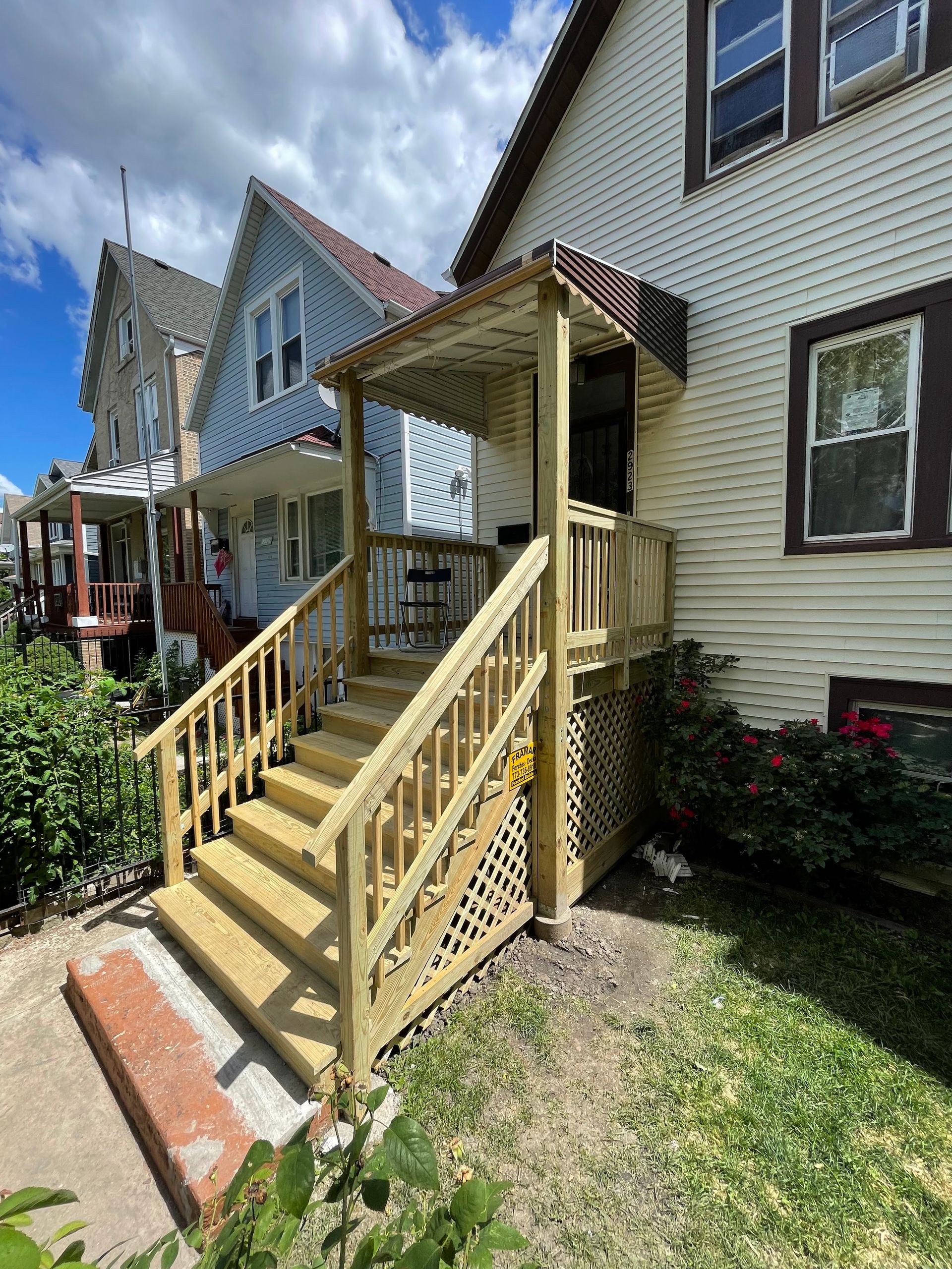 A house with a wooden porch and stairs in front of it.