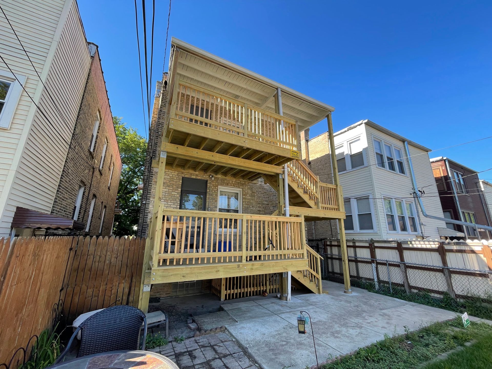 The back of a house with a wooden deck and stairs.